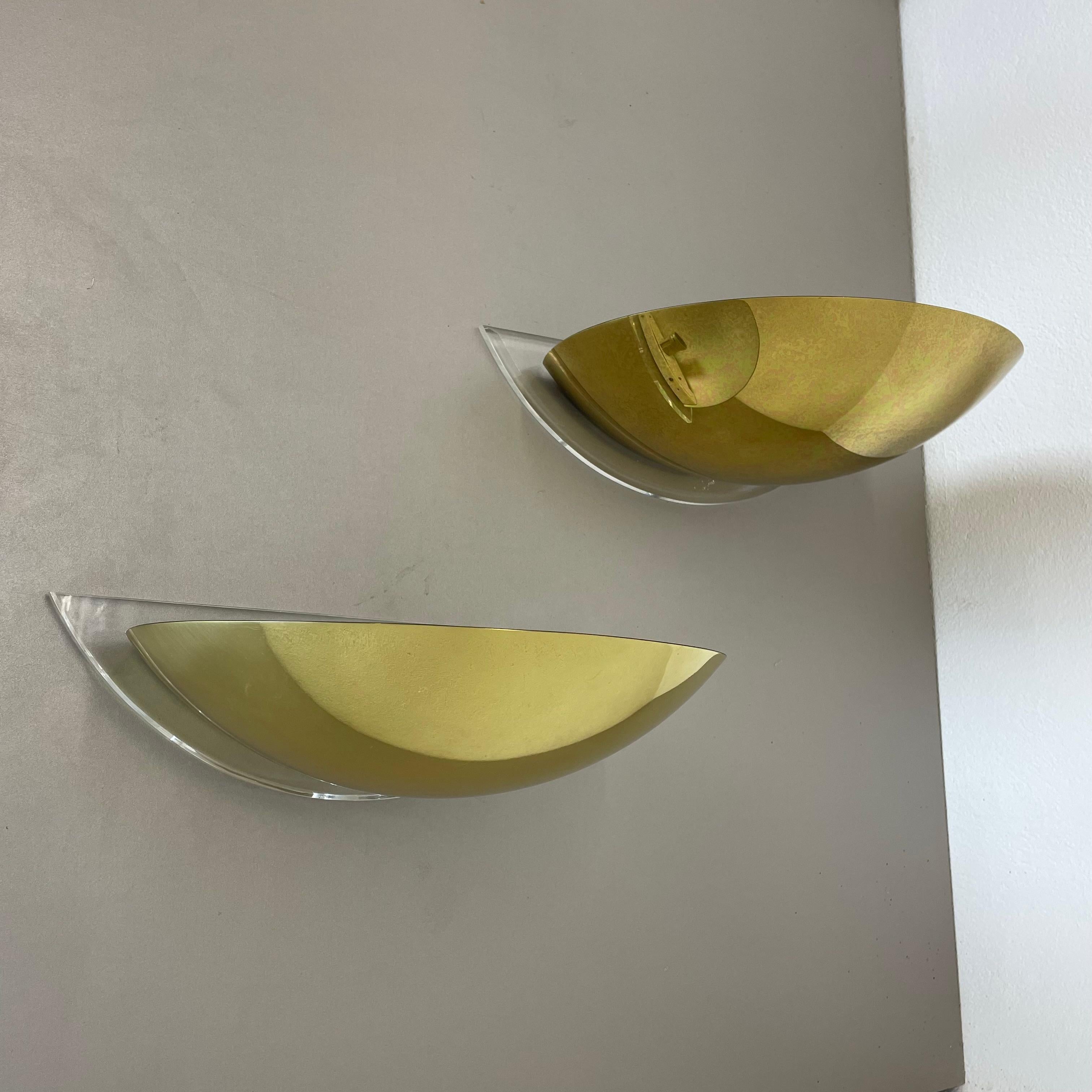 Article:

Wall light, set of 2 uplights


Origin:

Germany

Vereinigte Werkstätten attrib.



Age:

1970s



This vintage wall light set was produced in Germany in the 1970s. It is made of metal, brass and acryl lucid glass. It features a very
