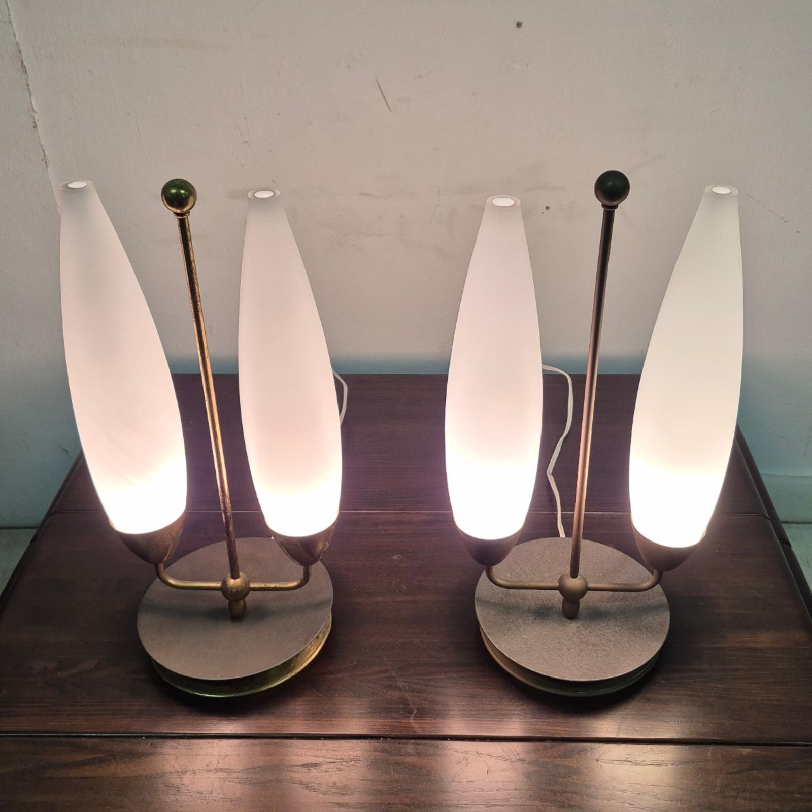 Elegant ensemble de lampes de table. Les lampes sont fabriquées en laiton et en métal. Chaque lampe possède 2 abat-jours en verre opalin. Les deux lampes présentent des traces d'usure et de patine, la lampe sur la photo de gauche étant la plus