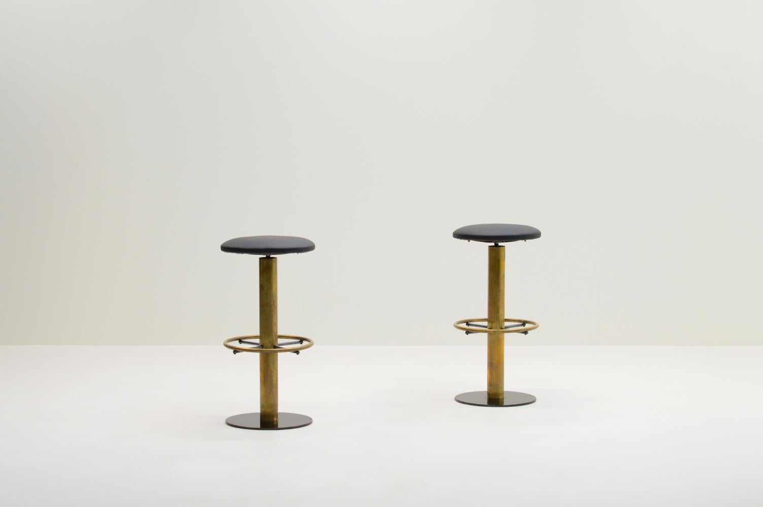 Set of 2 bar stools, 1950s Italy. The seats are reupholstered in black faux leather. They have a bearing swivel system. The base is made of Brass and metal. Heavy and sturdy stools. The brass has a nice patina. In good vintage condition. 

