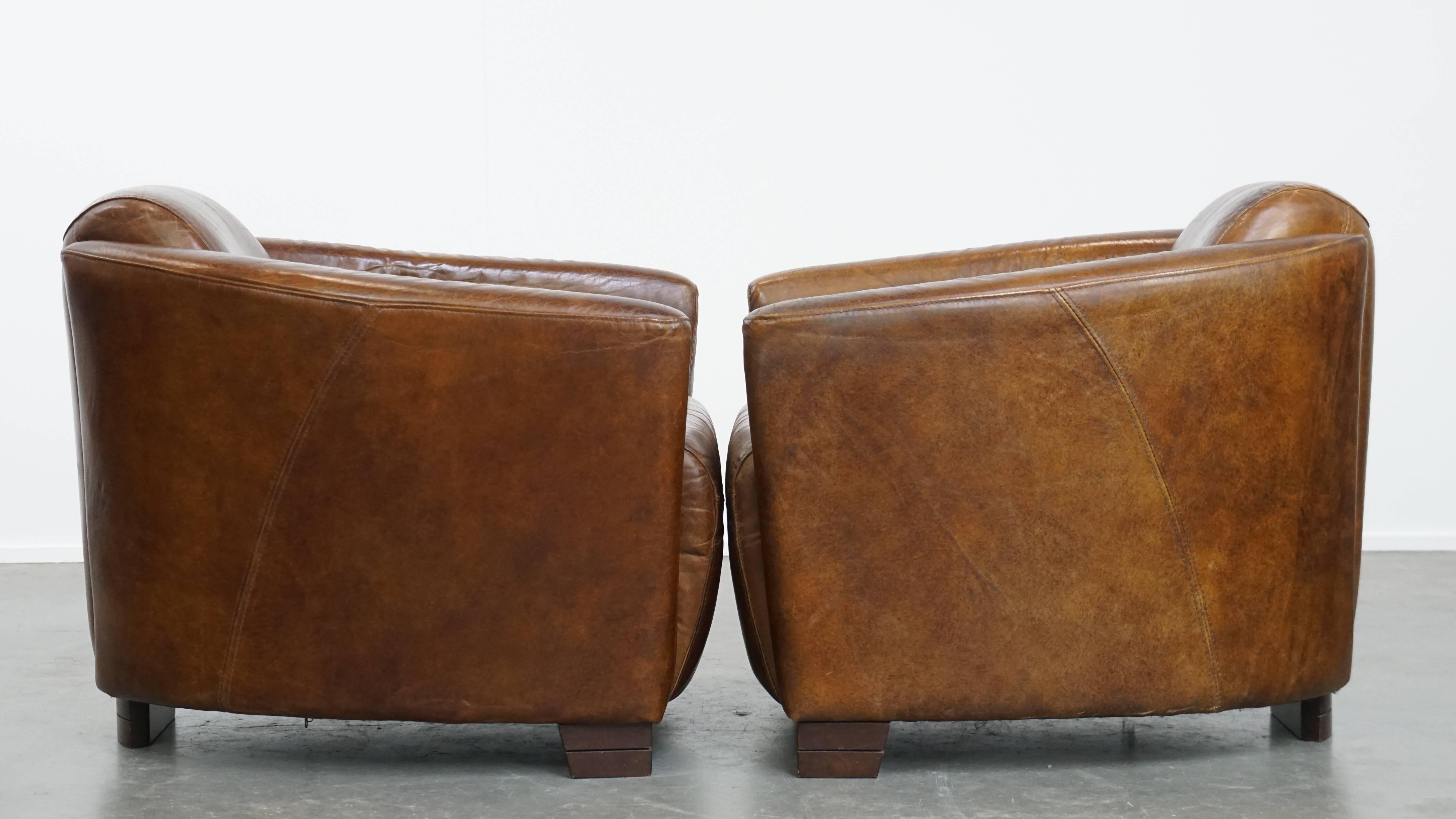 Offered here is this set of 2 unique and comfortable brown cowhide leather Aviator design armchairs. This set of unique and timeless design armchairs, crafted from cowhide leather, is a true eye-catcher and fits perfectly into almost any interior
