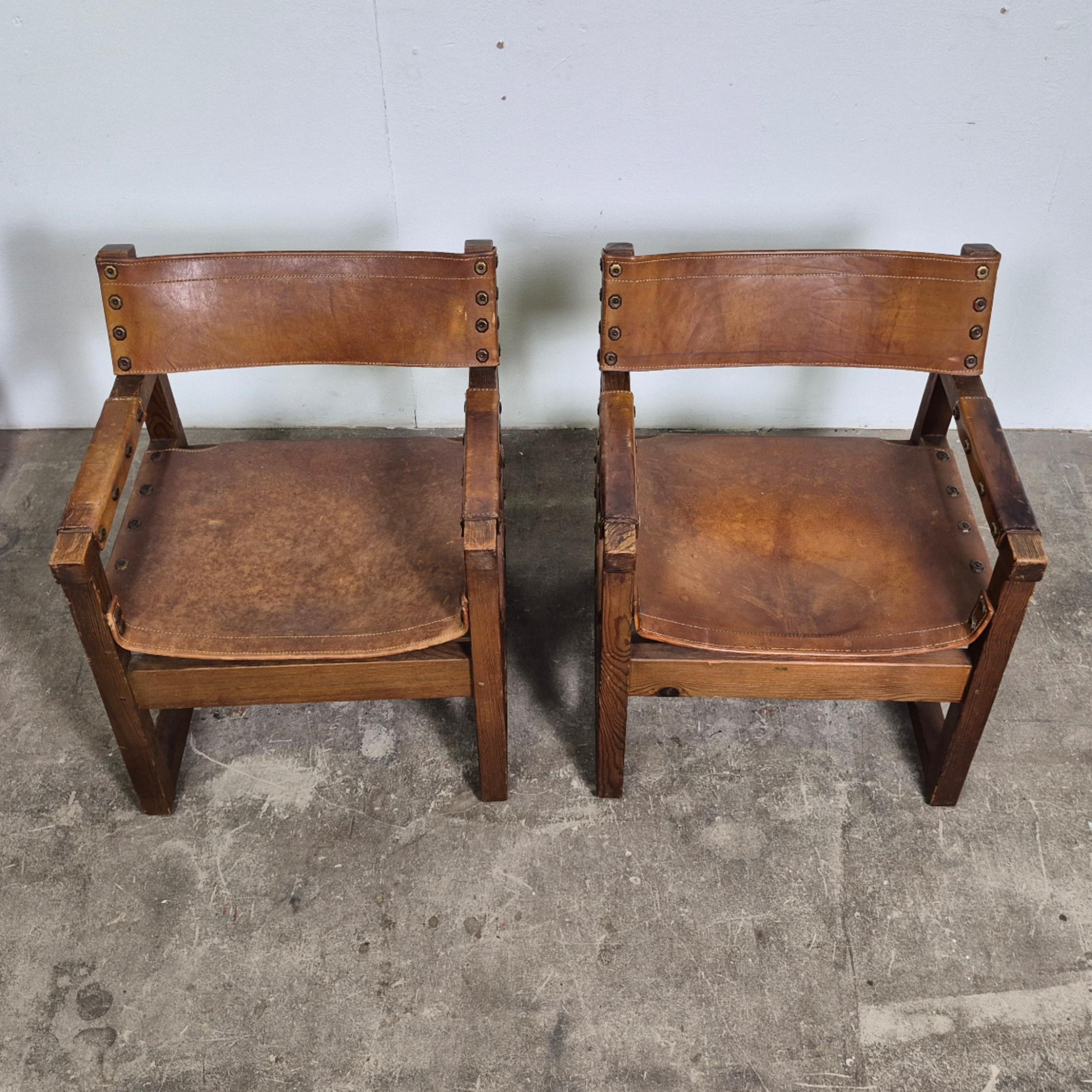 Realizzata in legno di pino con seduta e schienale in pelle spessa accentuata da borchie in ottone. Forme pure e materiali naturali rendono questa sedia una gioia per gli occhi. Prodotto dall'azienda spagnola BIOSCA negli anni Cinquanta.

Entrambe