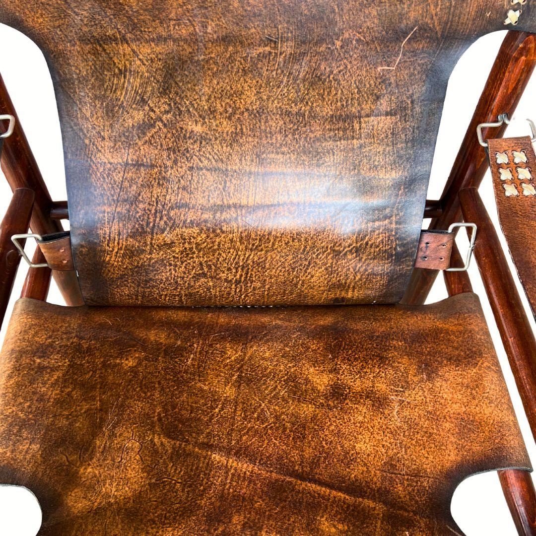 Un ensemble unique de 2 chaises de safari, conservées dans un état presque impeccable. Le cadre en bois massif et les surfaces en cuir définissent l'ensemble, ce qui en fait un choix parfait pour un bureau ou un salon. Leur style rappelle celui des