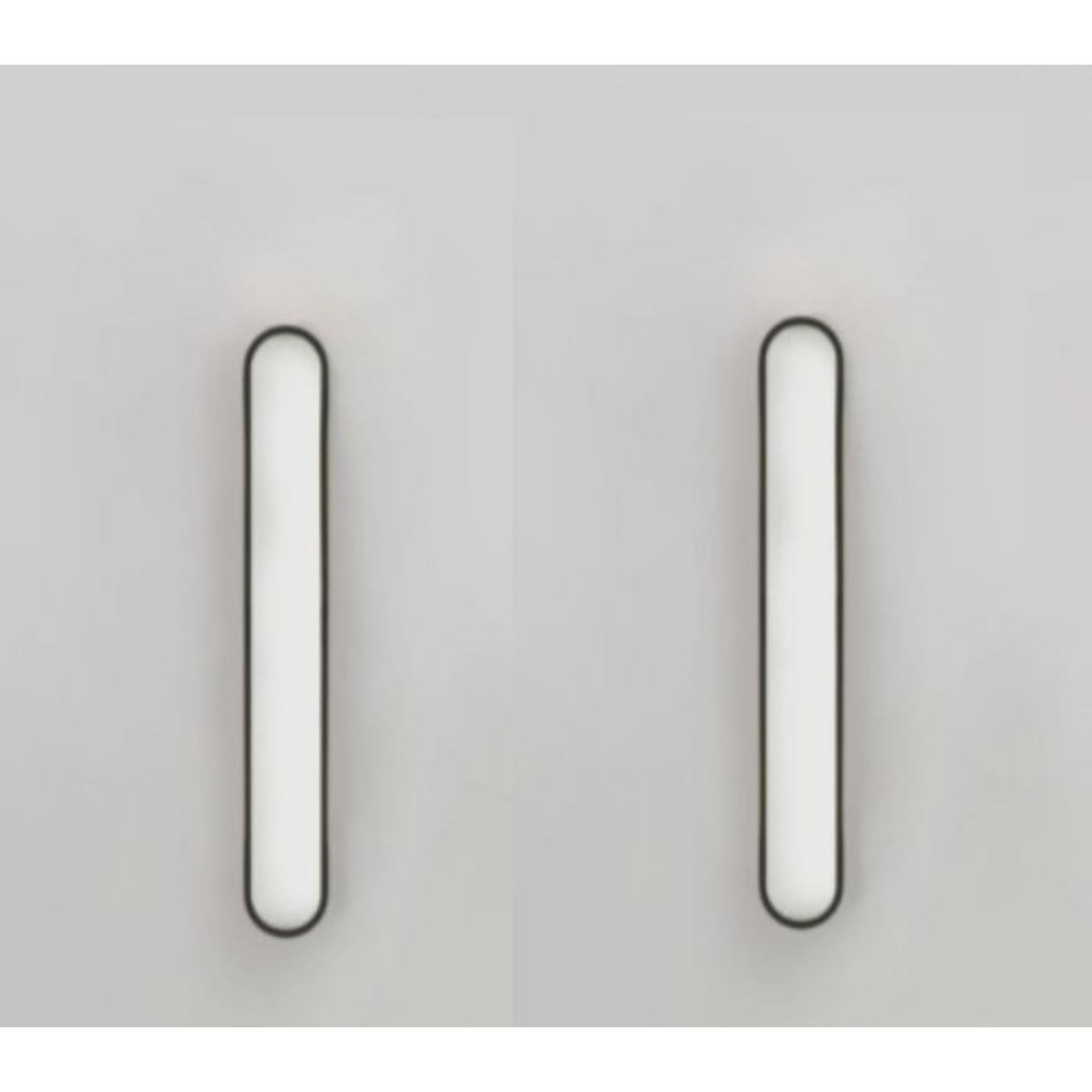 Set of 2 Capsule black wall lights by Square in Circle
Dimensions: D5 x W5.5 x H40 cm
Materials:Brushed brass/ opaque glass
Other finishes available.

Perfect rounded rectangular shape wall light. Metal wall light is neatly fixed with the same