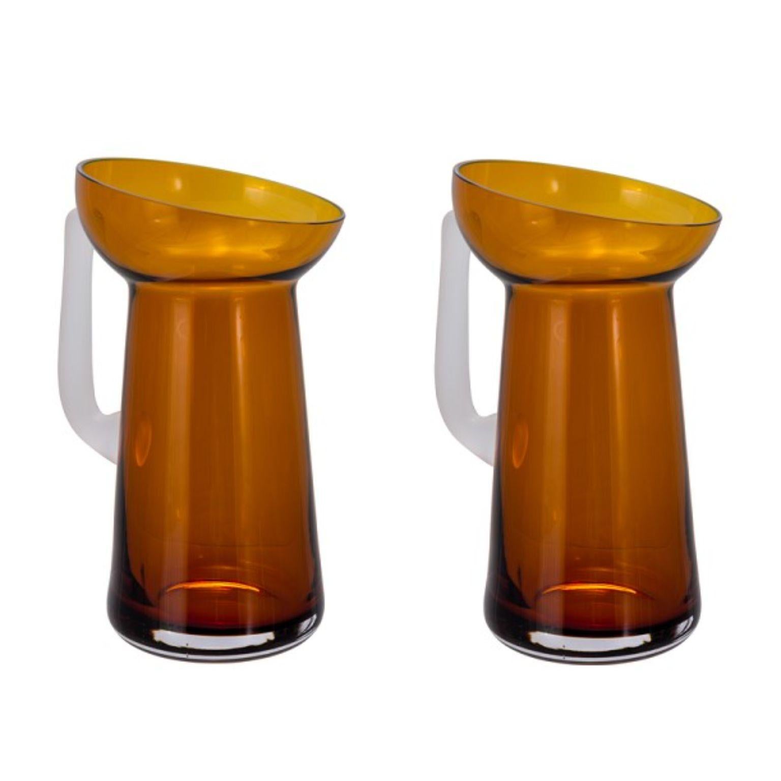 Set of 2 Carafes dark amber and transparent by Pulpo
Dimensions: D15 x H28.5 cm
Materials: handmade glass

Pick them, pour them, roll them, and hold them; a kaleidoscope of colour, form and texture awaits. The potpourri collections by German