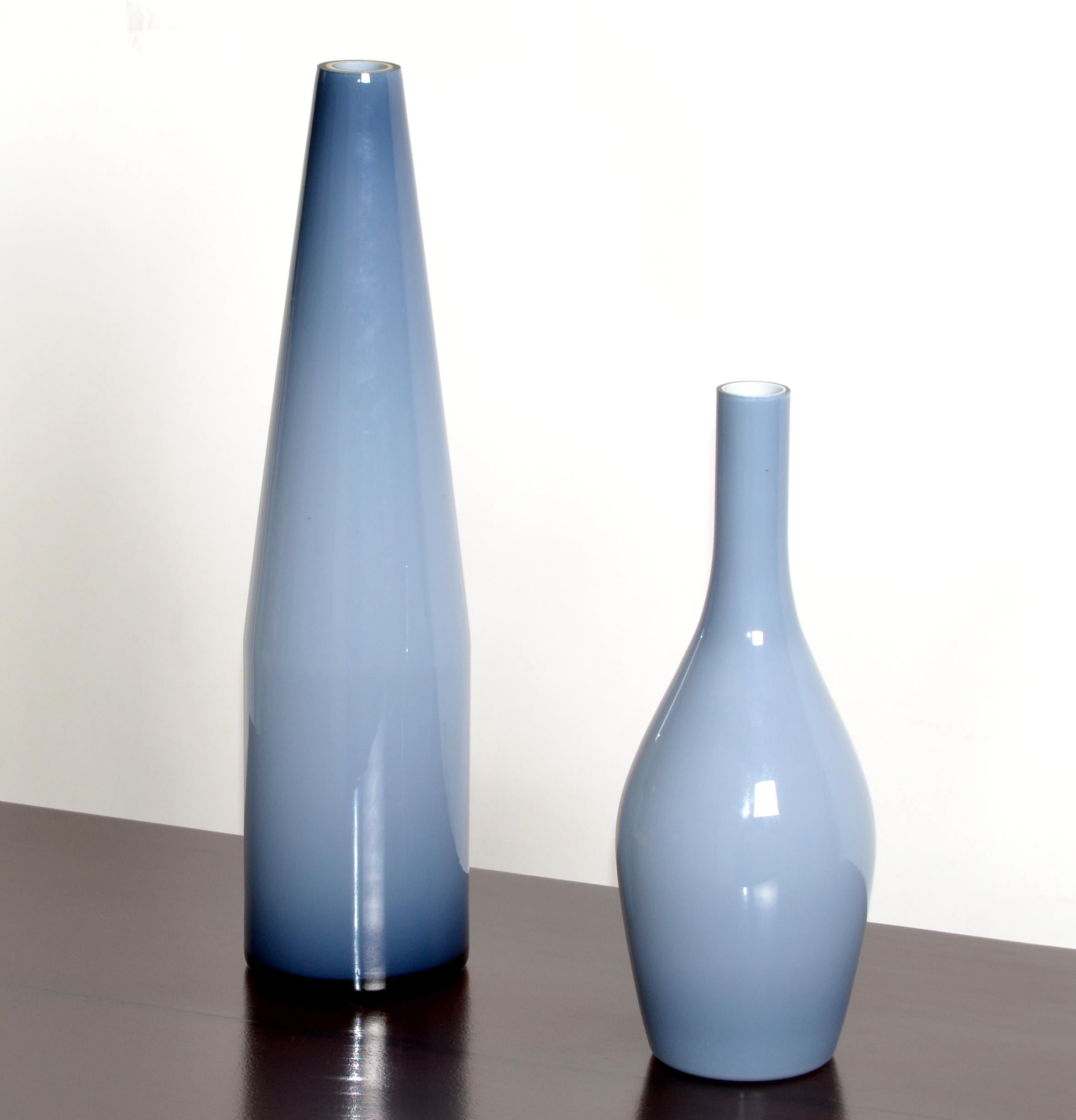 Set of 2 Carlo Moretti blue & white encased blown Murano glass vases made by Raymor in the 1980 and made in Italy.
Each vase is marked underneath with label and numbered.
The smaller vessel measures 11.5 inches in height.   
 