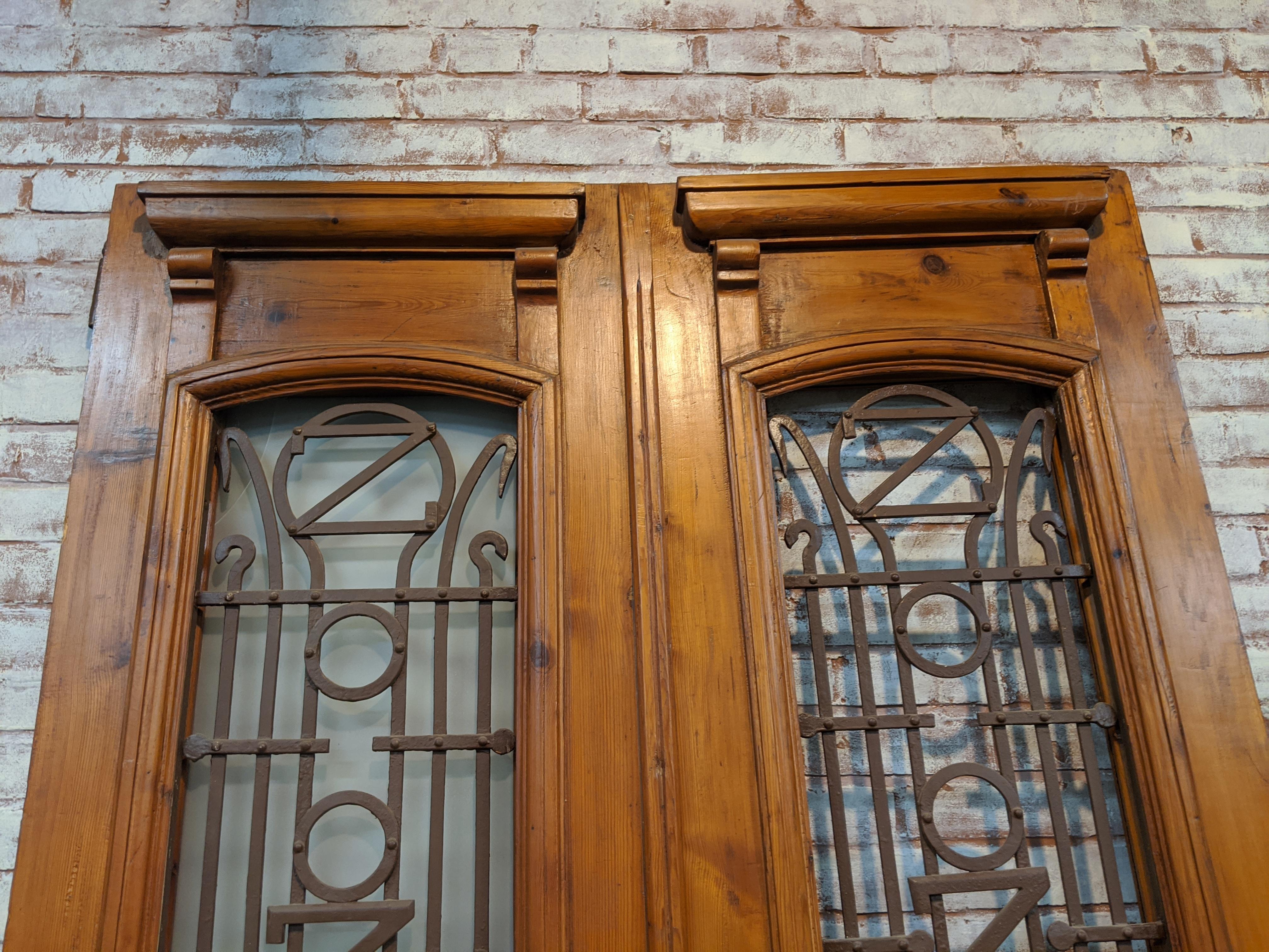Pair of vintage doors from Egypt. All paint has been removed and doors have a waxed finish. Original ironwork also cleaned. Each door measures 23 1/2