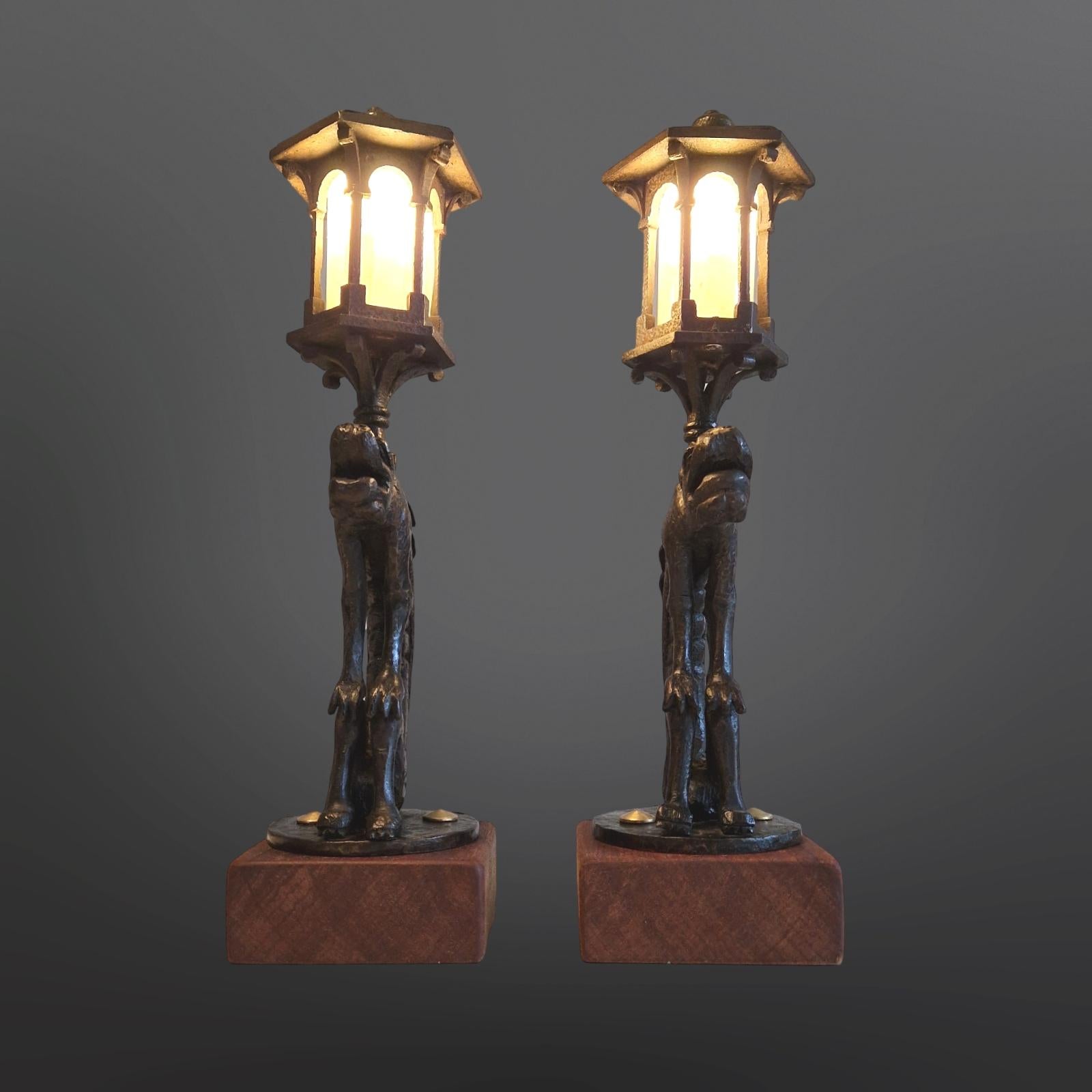 Set of 2 antique lanterns. They are made from cast iron and depict a griffin. They most likely came from a stair where they were placed on each side of the baluster. Illuminated lantern on top. The electrics have been redone. New wiring, switch and