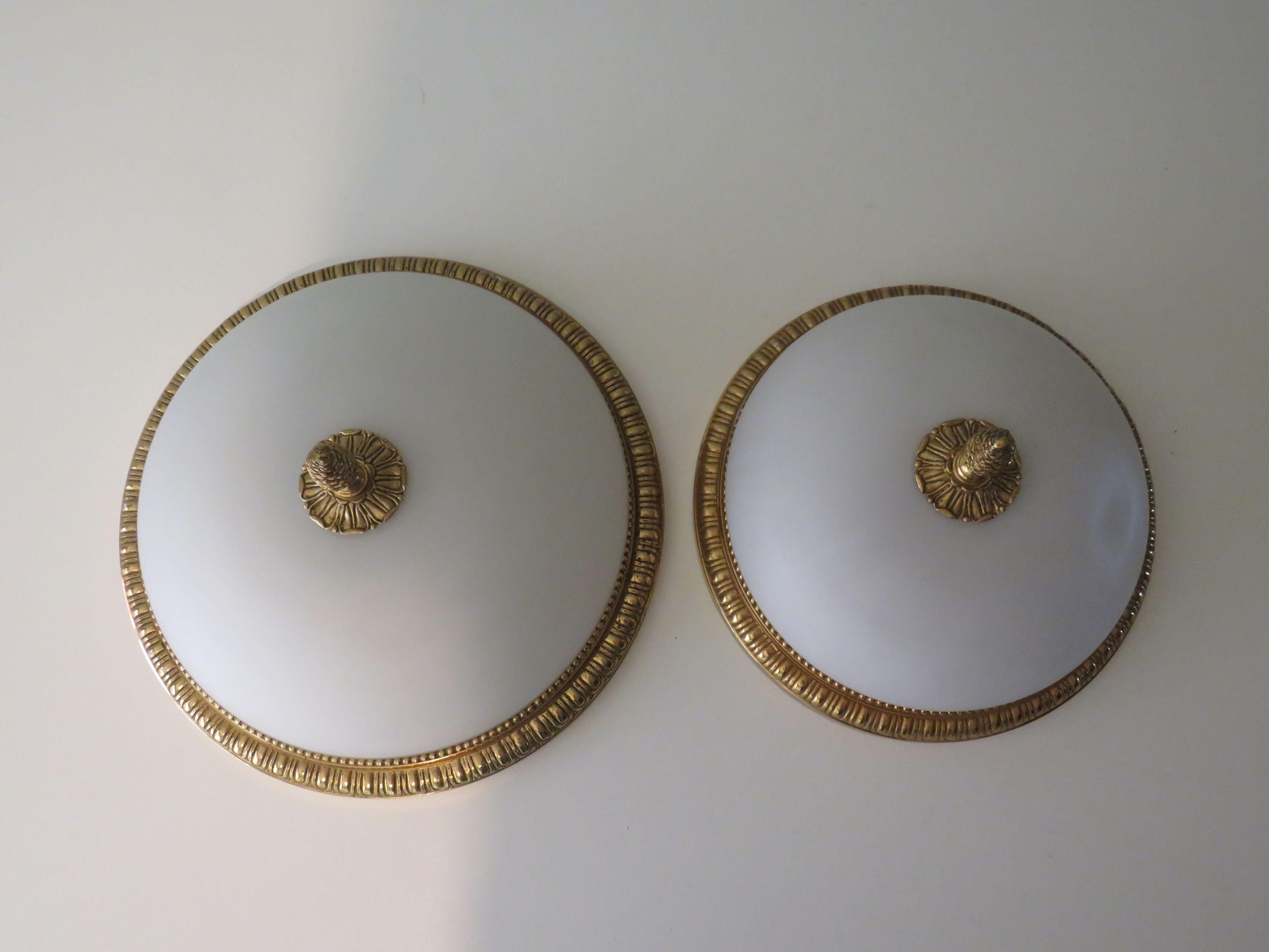 Very high-quality ceiling or wall lamps with gold-coloured bronze rim, white, opaline glass dome and finished with rosette and pine cone top.
Both lamps are equipped with 2 copper E 14 fittings.
The lamps are not the same size!
The large lamp has