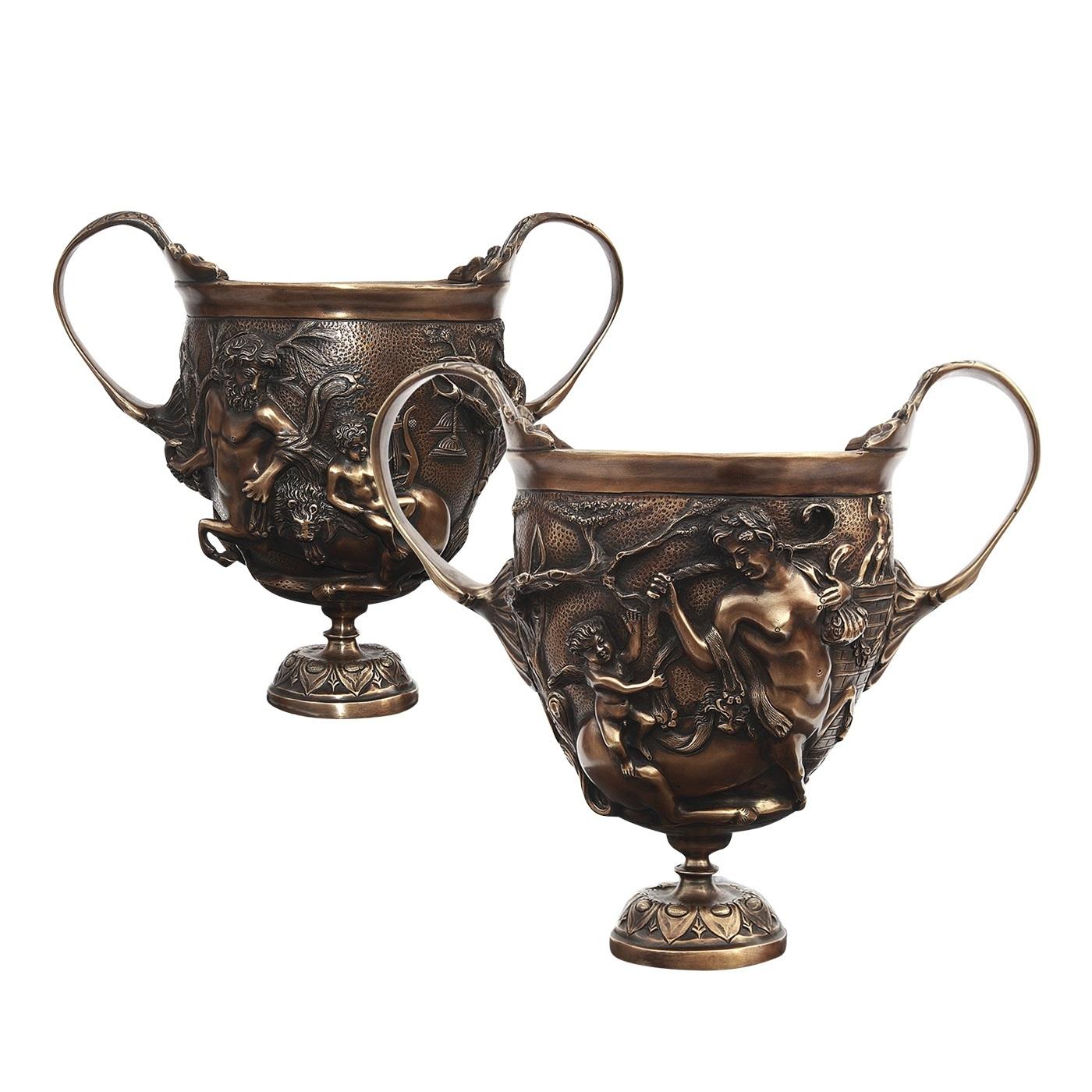 This set of two bronze goblets is an accurate reproduction of ancient Roman silver glasses found in the ruins of Pompei and now on display at the National Archeological Museum of Naples. These elegant pieces feature a splendid bas relief depicting a