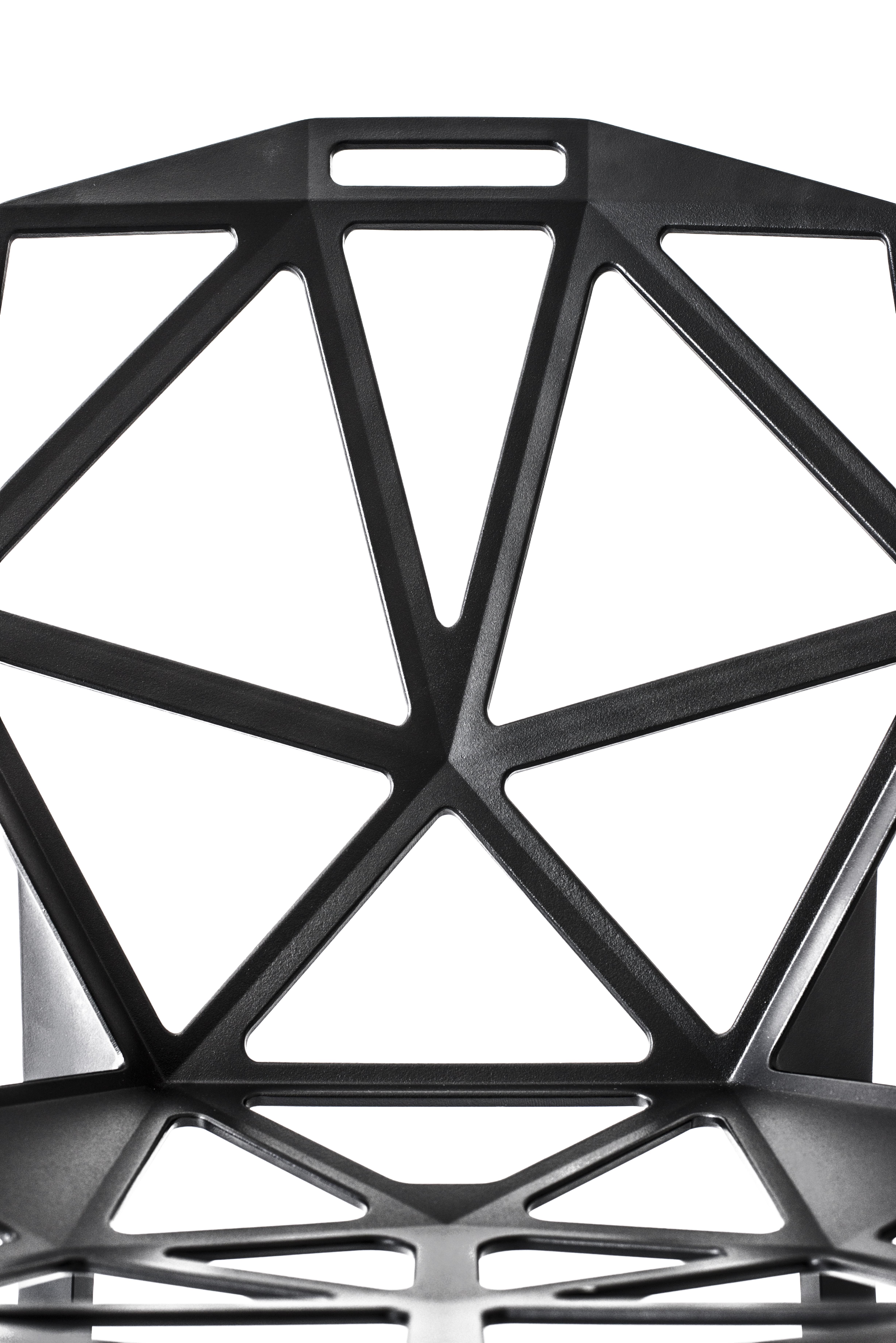 Ein Gehäuse aus Aluminiumdruckguss, das aus vielen kleinen, gelochten und dreieckigen Flächen besteht. Chair_One ist in gewisser Weise wie ein Fußball gebaut, d.h. aus einer Reihe von flachen Elementen, die in einem Winkel aneinandergefügt sind und