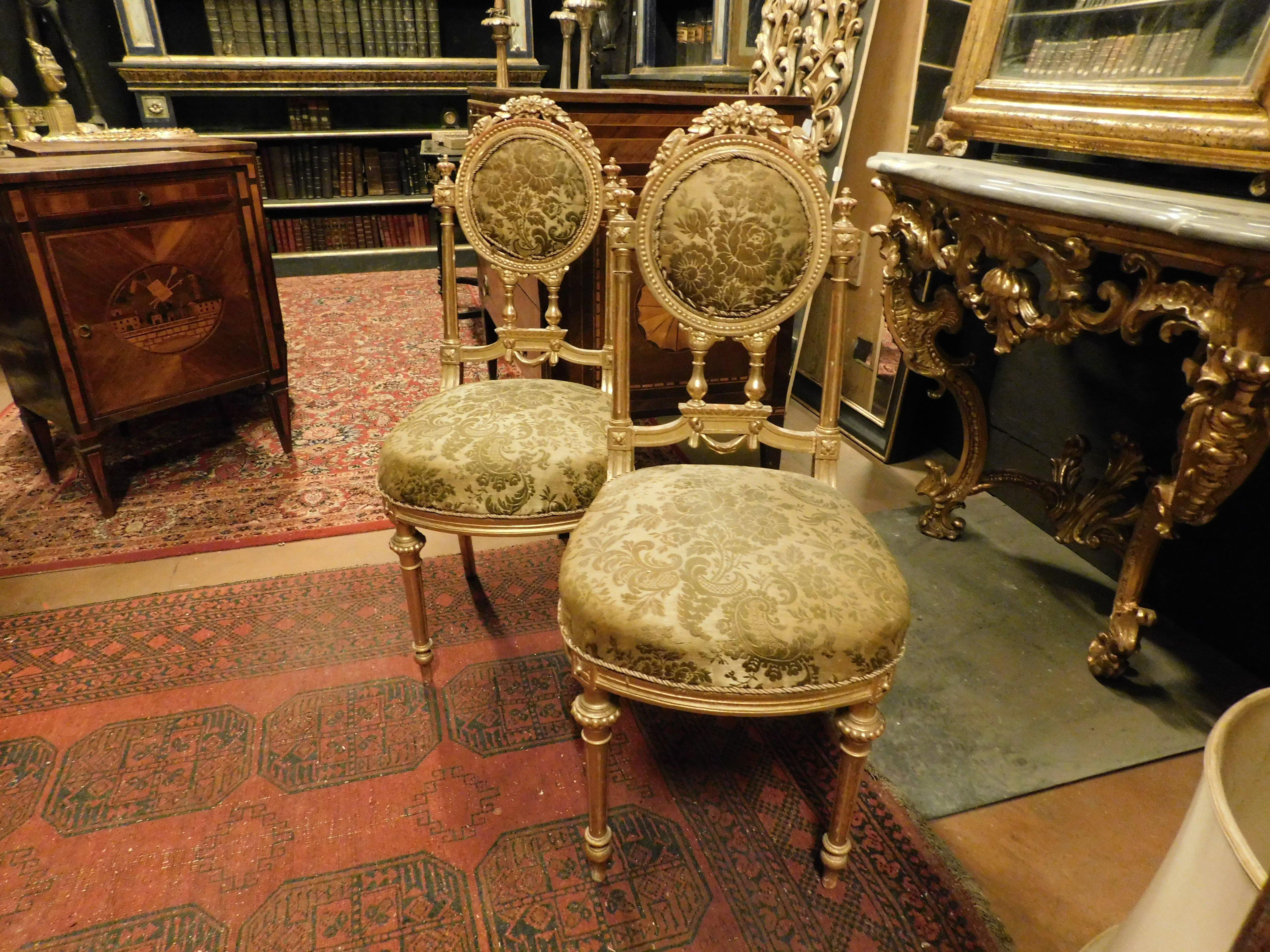 set di 2 sedie antiche in legno dorato e riccamente intagliato, Schienale ovale riccamente intagliato, formato da balaustre, gambe scanalate e dorate. Schienale e seduta imbottiti e rivestiti con tessuto a motivi floreali. Originale del XVIII