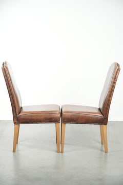 Set of 2 characterful dining chairs of sheepskin leather with a high back
