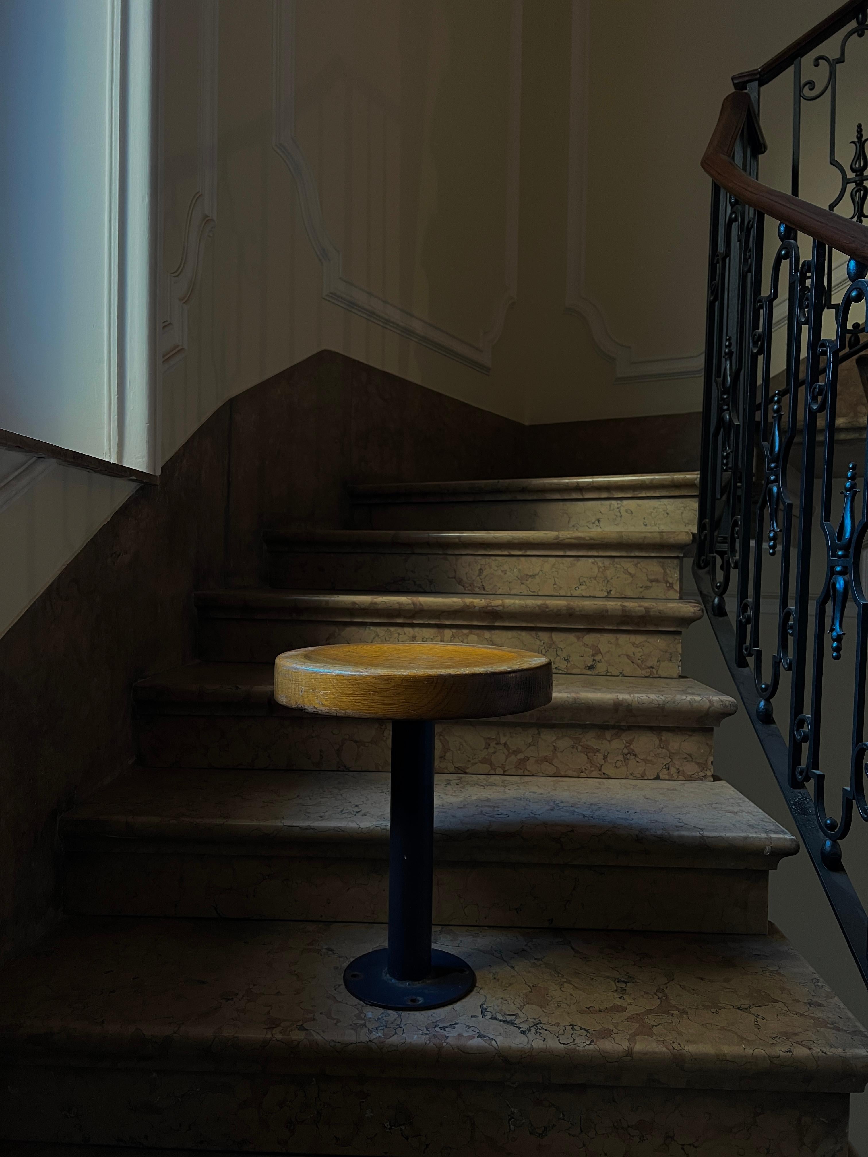 Fantastic and hard to find pair of fixed stools designed and manufactured by Charlotte Perriand for French ski resort Les Arcs Savoie. The solid pine seat rests on a blue lacquer metal pole and base. The stools are in original condition and have a