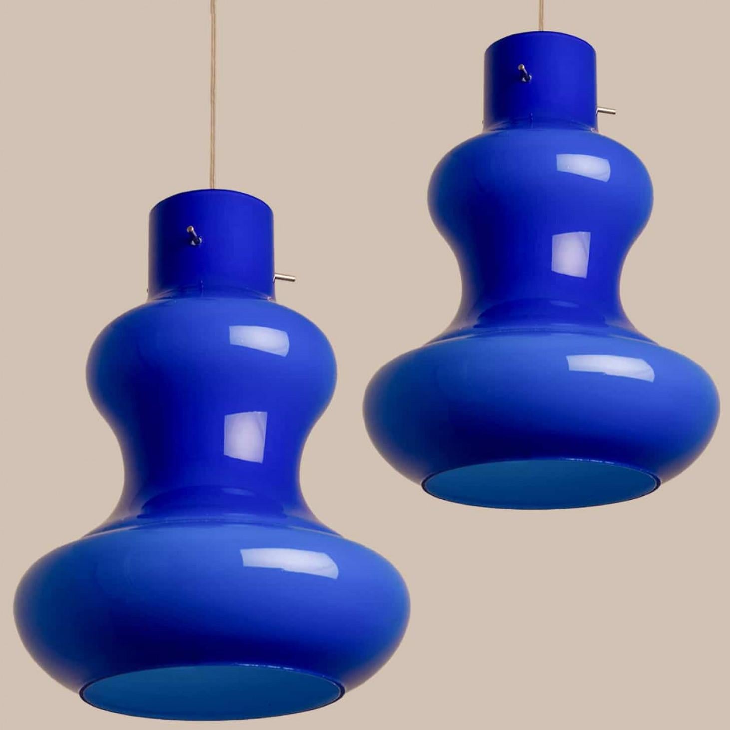 A beautiful and unique set of cobalt blue glass pendant lights, made in the 1960s by Massimo Vignelli for Venini.
The lampshade is made of blue opaline glass with an inner white glaze. Real murano glass, made in Italy.

In very good vintage
