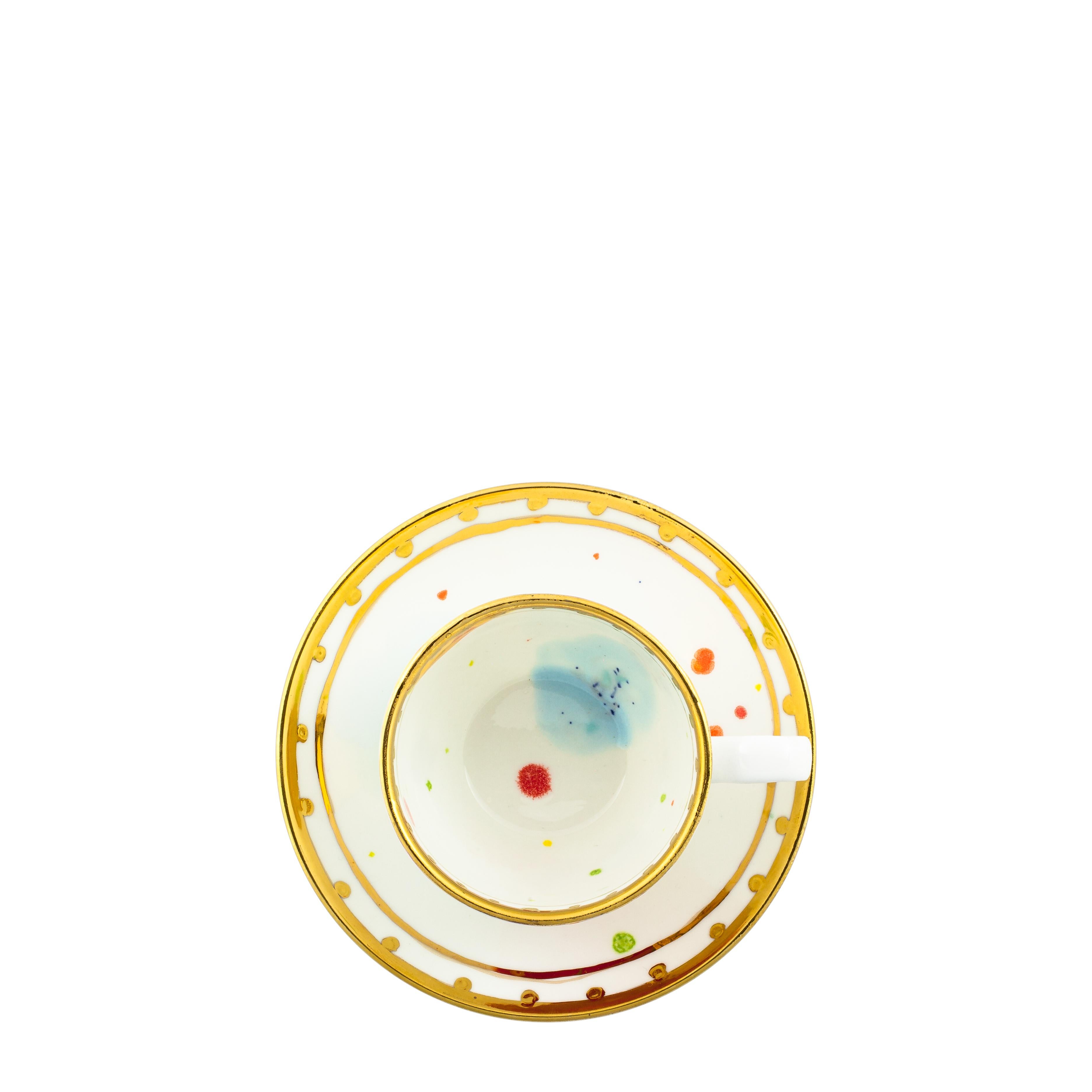 Handcrafted in Italy from the finest porcelain, this Caravaggio coffee cup and saucer is painted both inside and outside with red, yellow and light-blue splotches on a white enamel; an elegant golden rim turns inside like a medieval tower