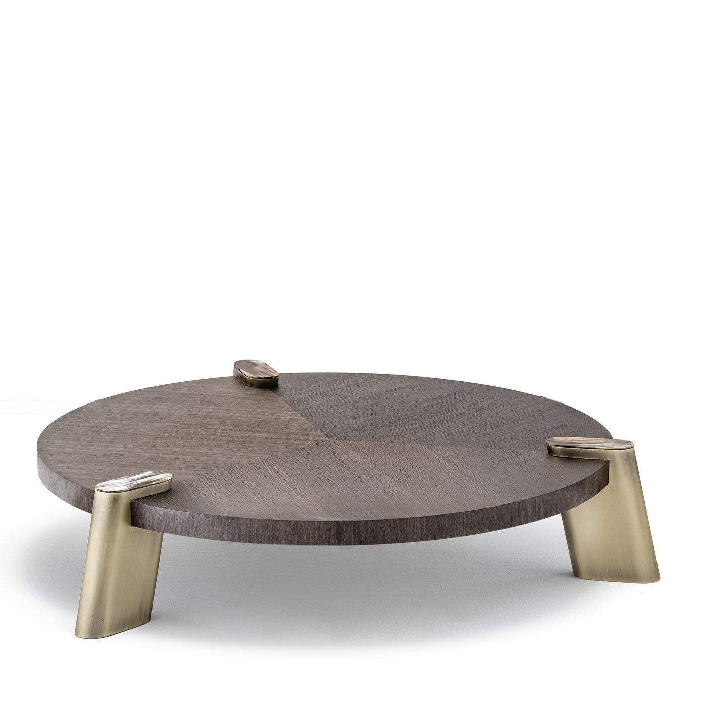 Defined by simple geometric lines, the striking elegance of these two coffee tables is all in the rich details. A stately round top in oak wood sits atop three slanted rectangular brass feet with rounded edges accented on top with natural horn. The