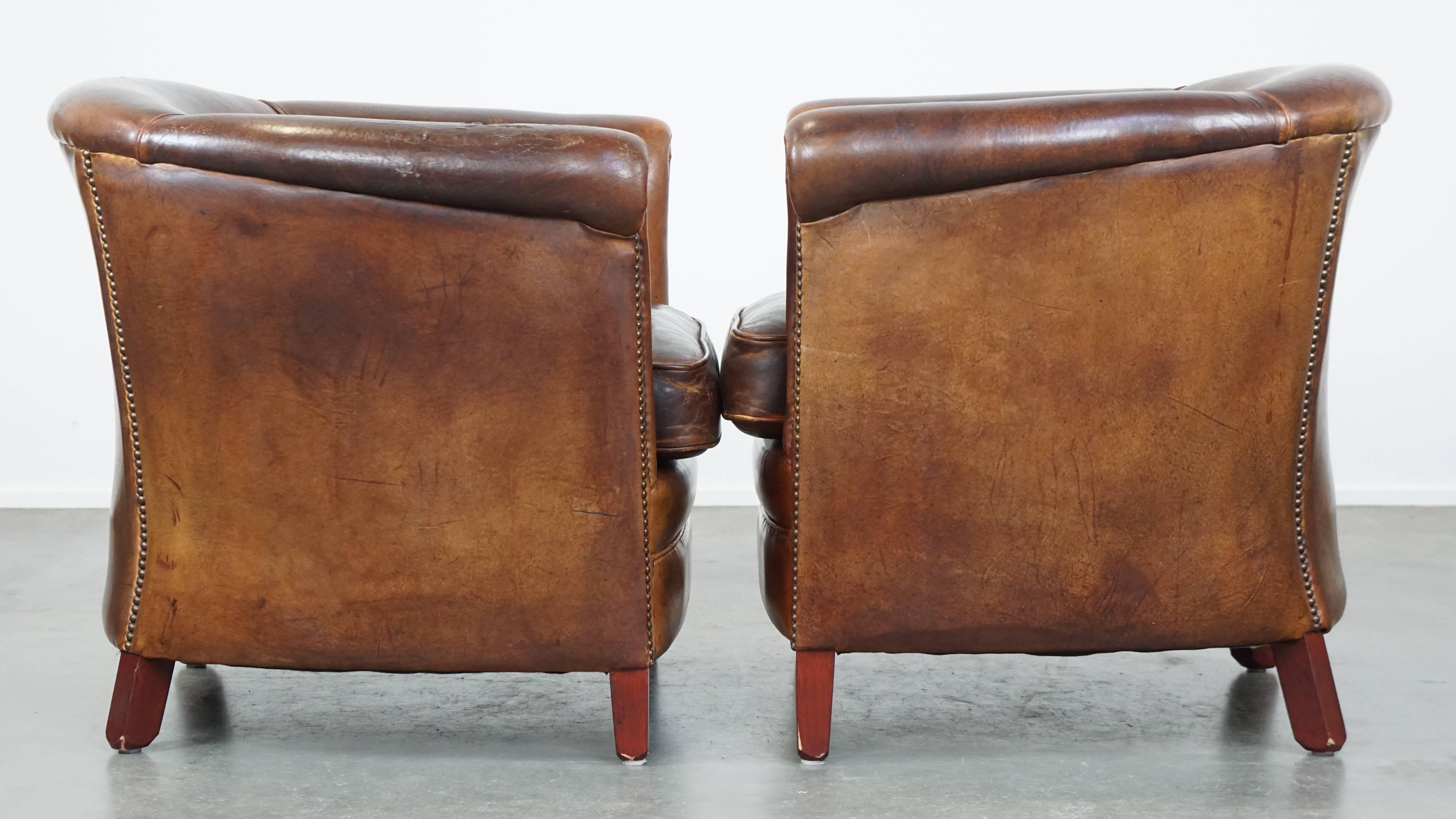 Nous vous proposons cet ensemble de 2 fauteuils club intemporels et robustes en cuir de mouton couleur cognac avec une finition correcte et une belle patine.

Cet ensemble de 2 fantastiques fauteuils club en cuir de mouton couleur cognac peut