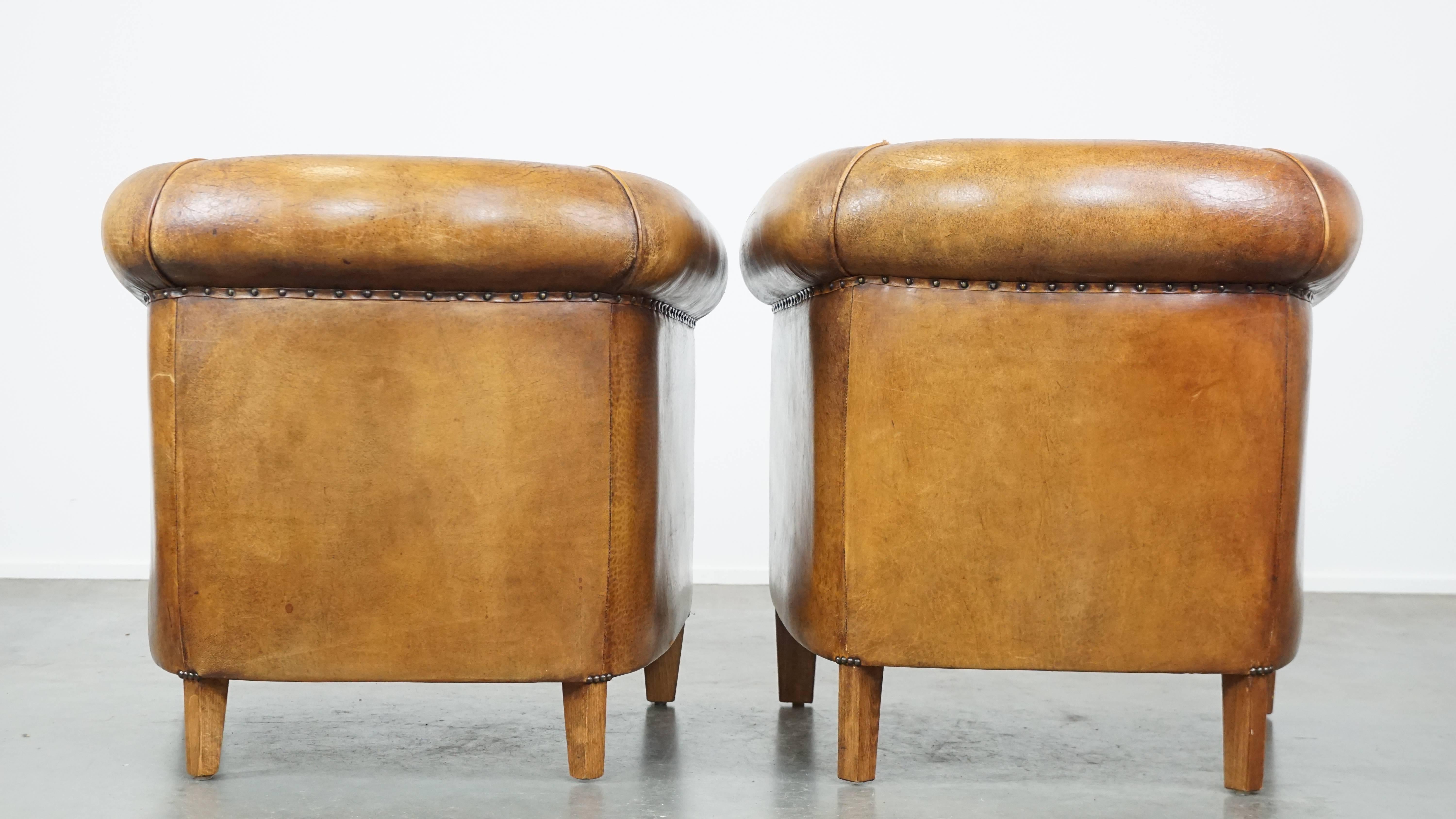 Set aus 2 cognacfarbenen Schafsfell-Clubsesseln mit bunten Stoff-Sitzkissen (Europäisch) im Angebot