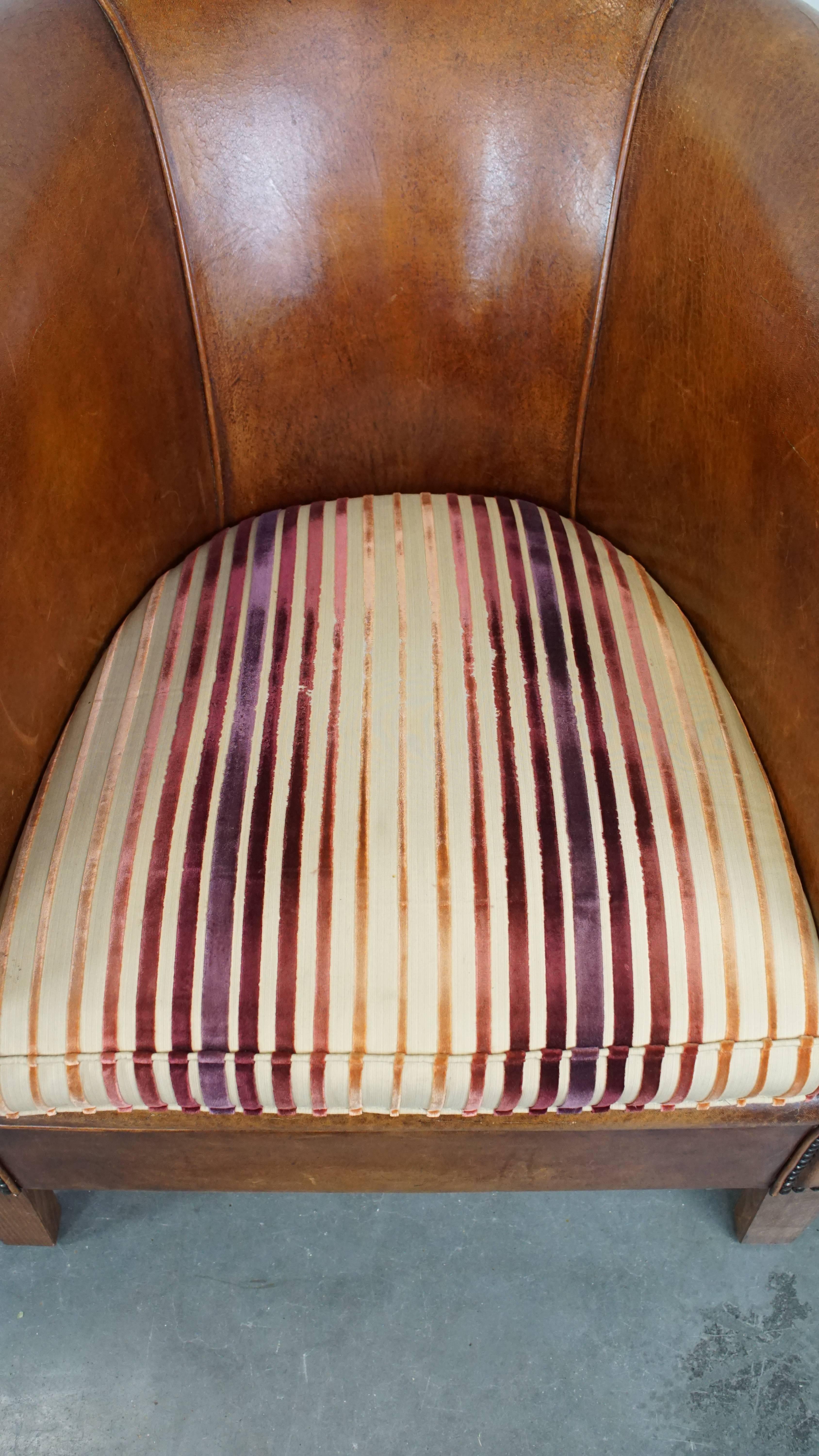 Set aus 2 cognacfarbenen Schafsfell-Clubsesseln mit bunten Stoff-Sitzkissen (Leder) im Angebot