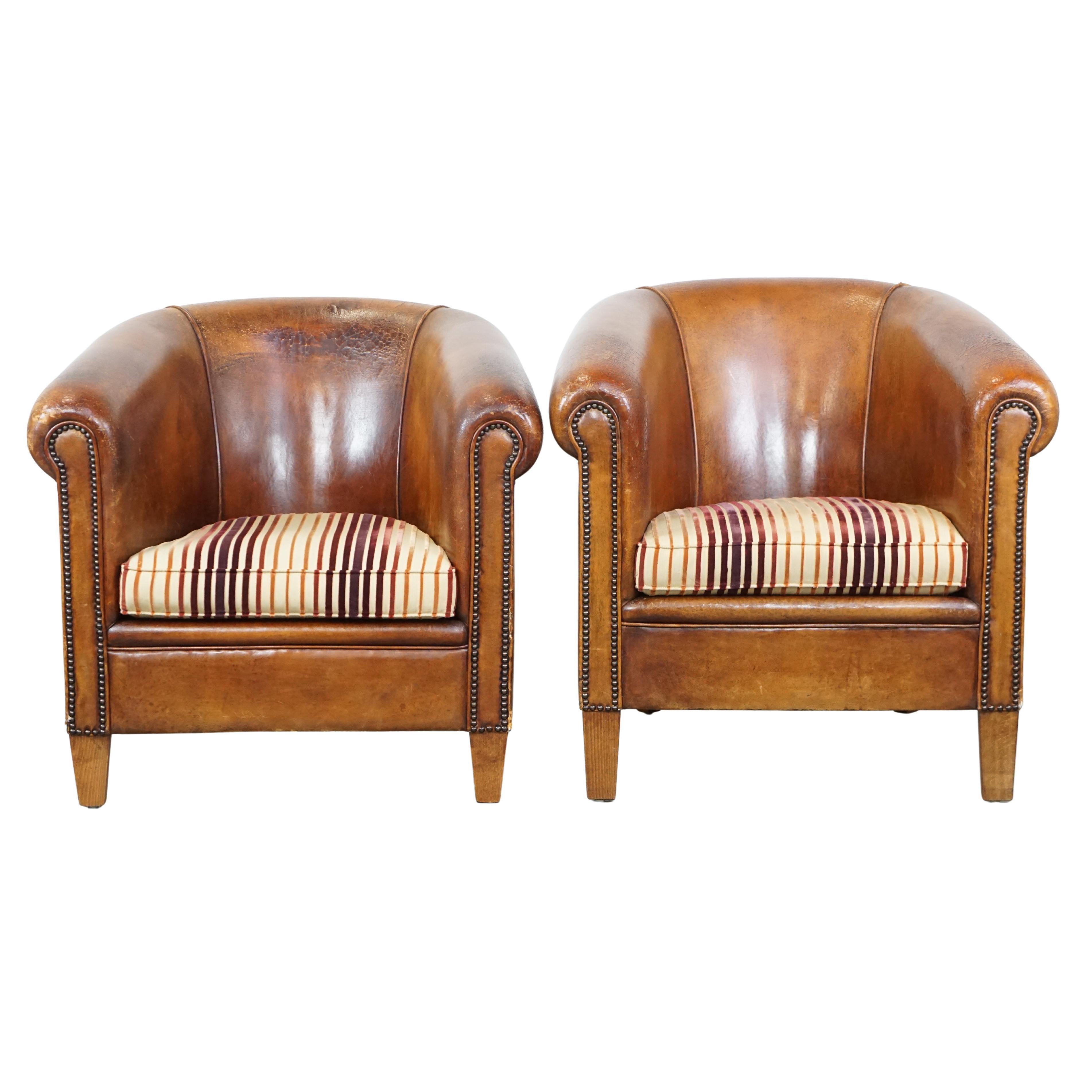 Set of 2 cognac-colored sheepskin club chairs with colorful fabric seat cushions