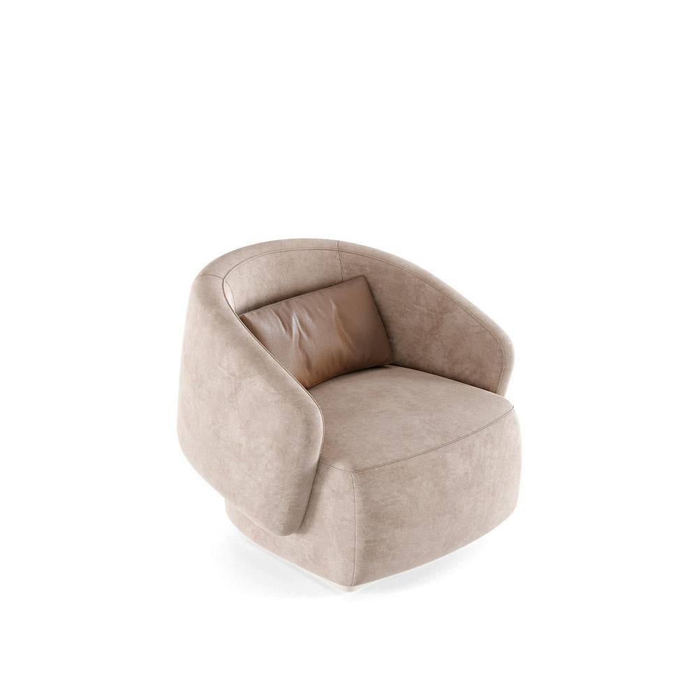 Questa poltrona presenta una sofisticata fusione di materiali, con un pannello dello schienale in pelle a contrasto perfettamente integrato con una base in morbido tessuto. Il profilo laterale evidenzia la qualità scultorea del suo design, mostrando