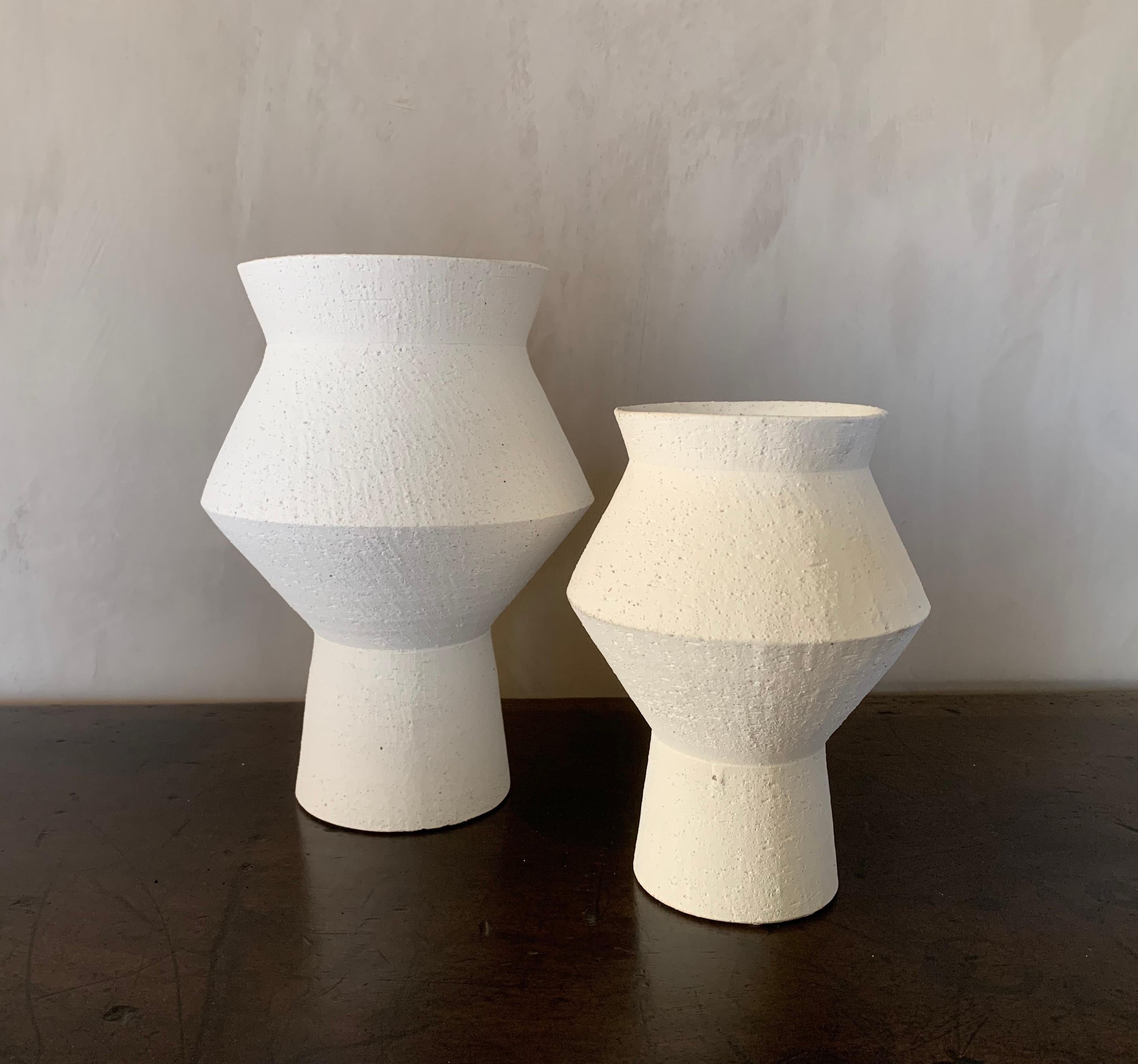 Un ensemble de 2 vases géométriques contemporains en céramique. L'extérieur du tapis n'est pas émaillé et l'intérieur est émaillé à la brosse. Des proportions adorables, des techniques classiques et un design moderniste.