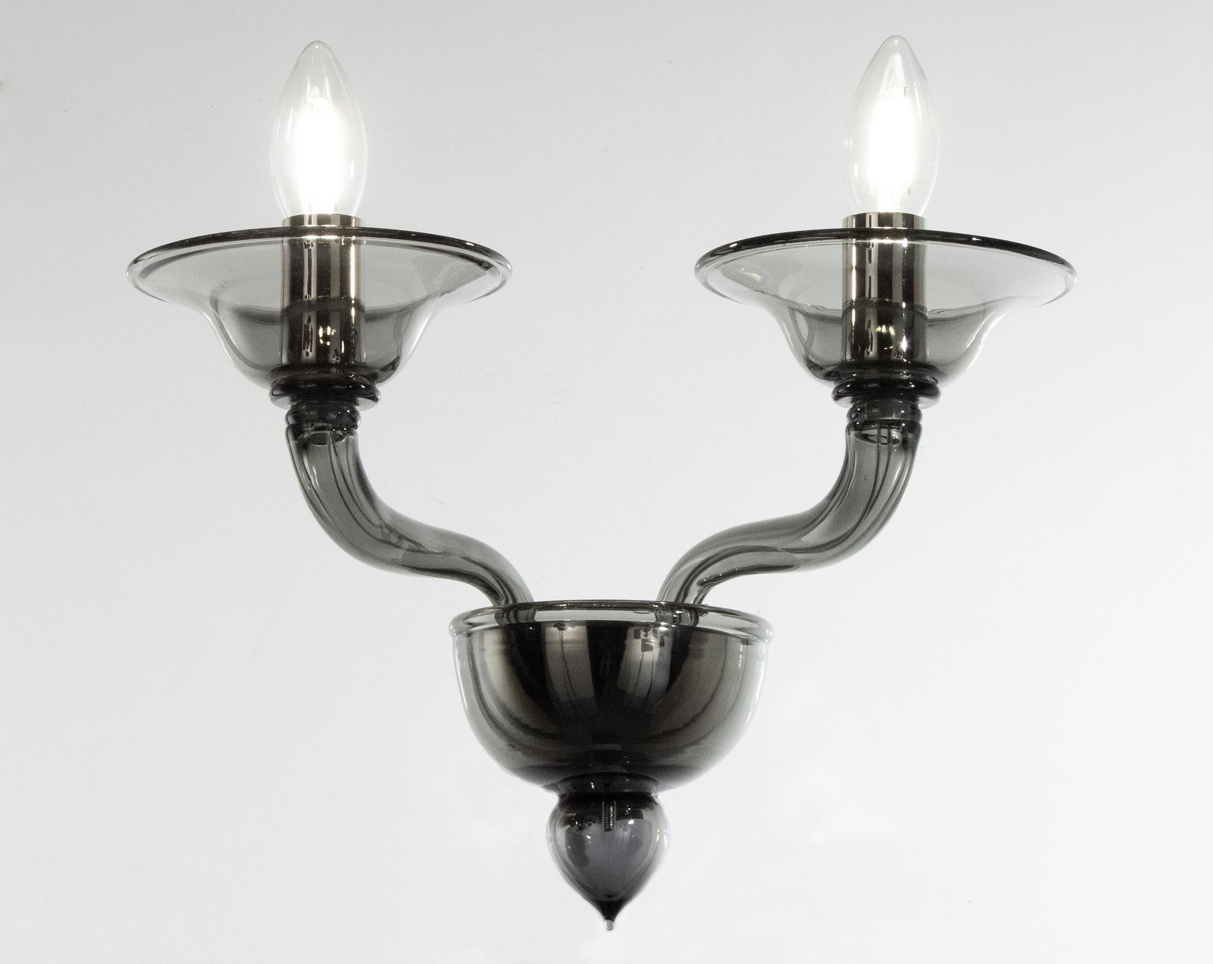 Set di 2 sconsole contemporanee a 2 bracci in vetro di Murano grigio scuro liscio di Multiforme

Applique Tobia Multiforme a 2 luci. Vetro di Murano grigio scuro liscio con braccia a castello che si arrampicano.
Il lampadario in vetro soffiato e le