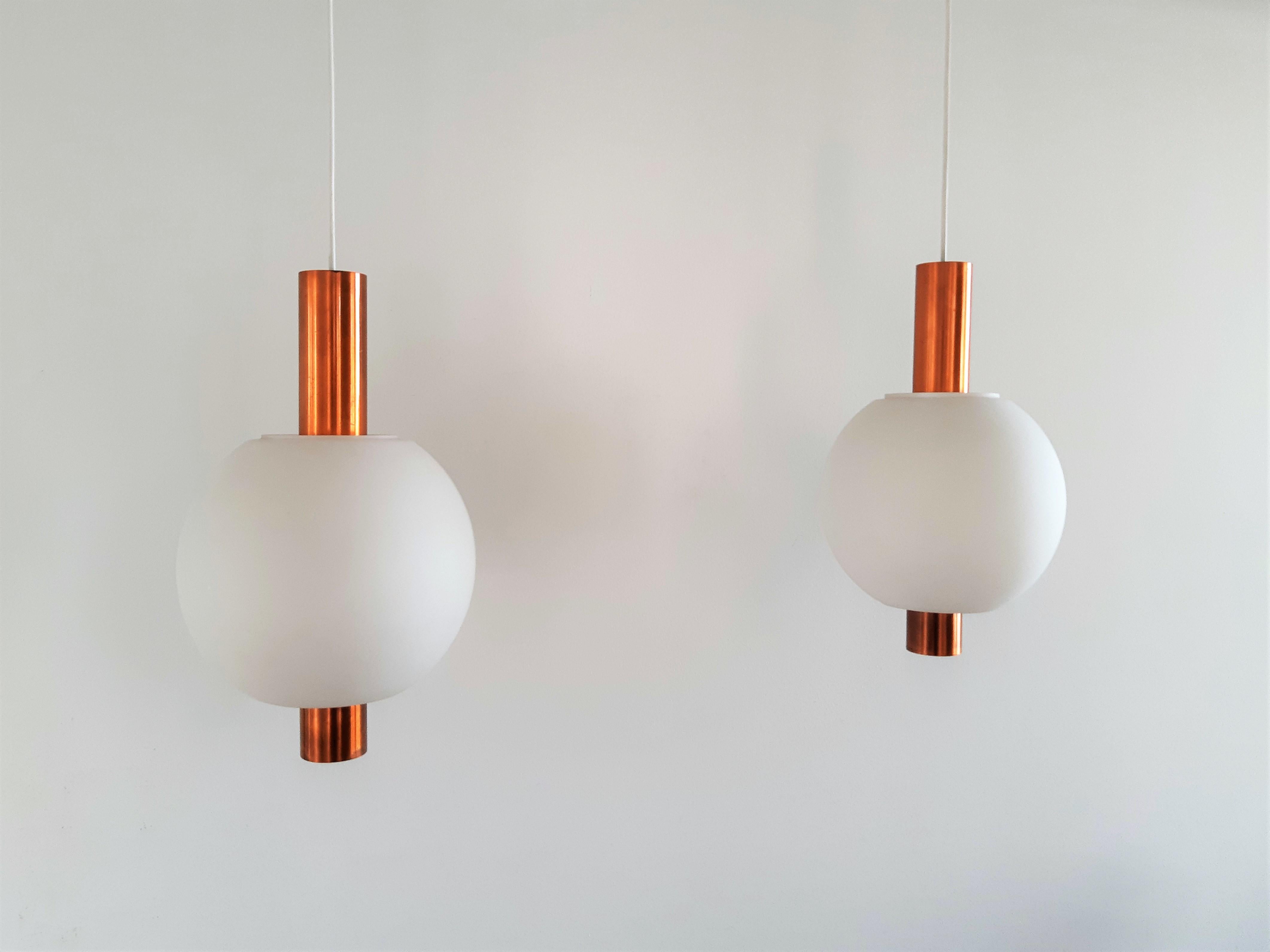 This beautiful and rare pendant lamp, model HL 7362, was made by Hiemstra Evolux. The lamp consists out of an opaline glass shell hanging on a copper shaft. It gives a very warm light due to the materials and color and it can add the finishing touch