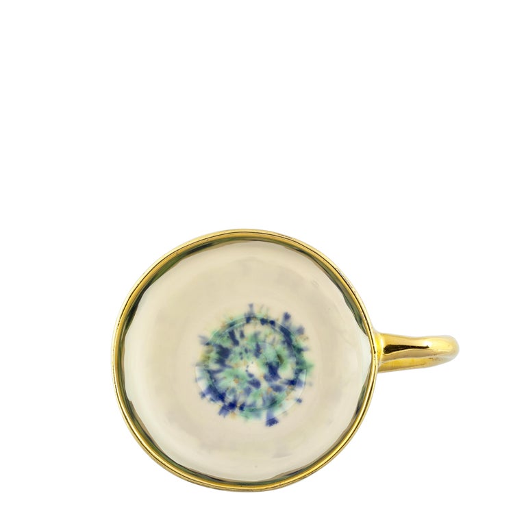 This Blue Marble Coralla's mug, shaped by Coralla Maiuri herself and a symbol of her work, is painted with a shiny white glaze outside emphasized by the elegantly thin golden handle and crowned by a rich drop edge golden rim; inside at the bottom is