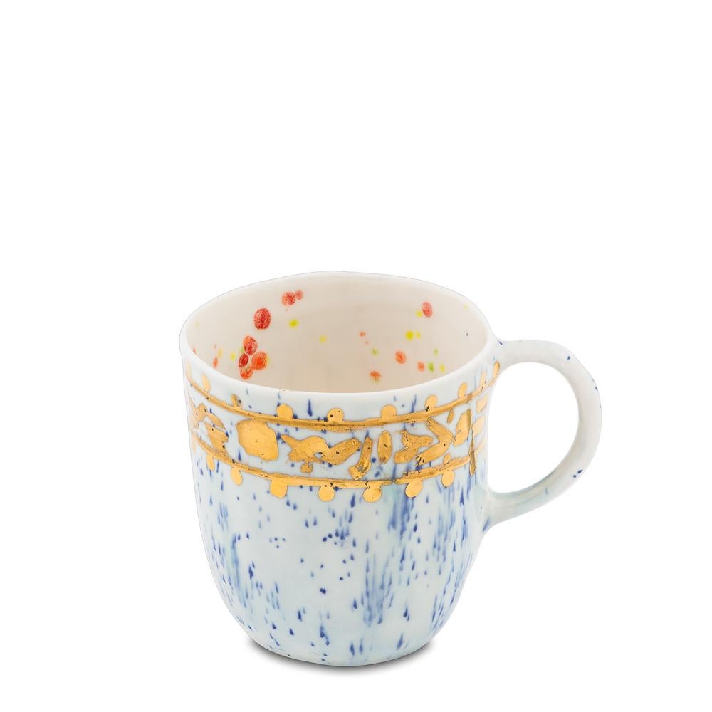 Handcrafted in Italy from the finest porcelain, Coralla's mugs are of her own design and a symbol of her work. Outside, this Caravaggio Coralla's mug is painted with blue dots on a light blue backdrop and a broad golden rim décor with classical