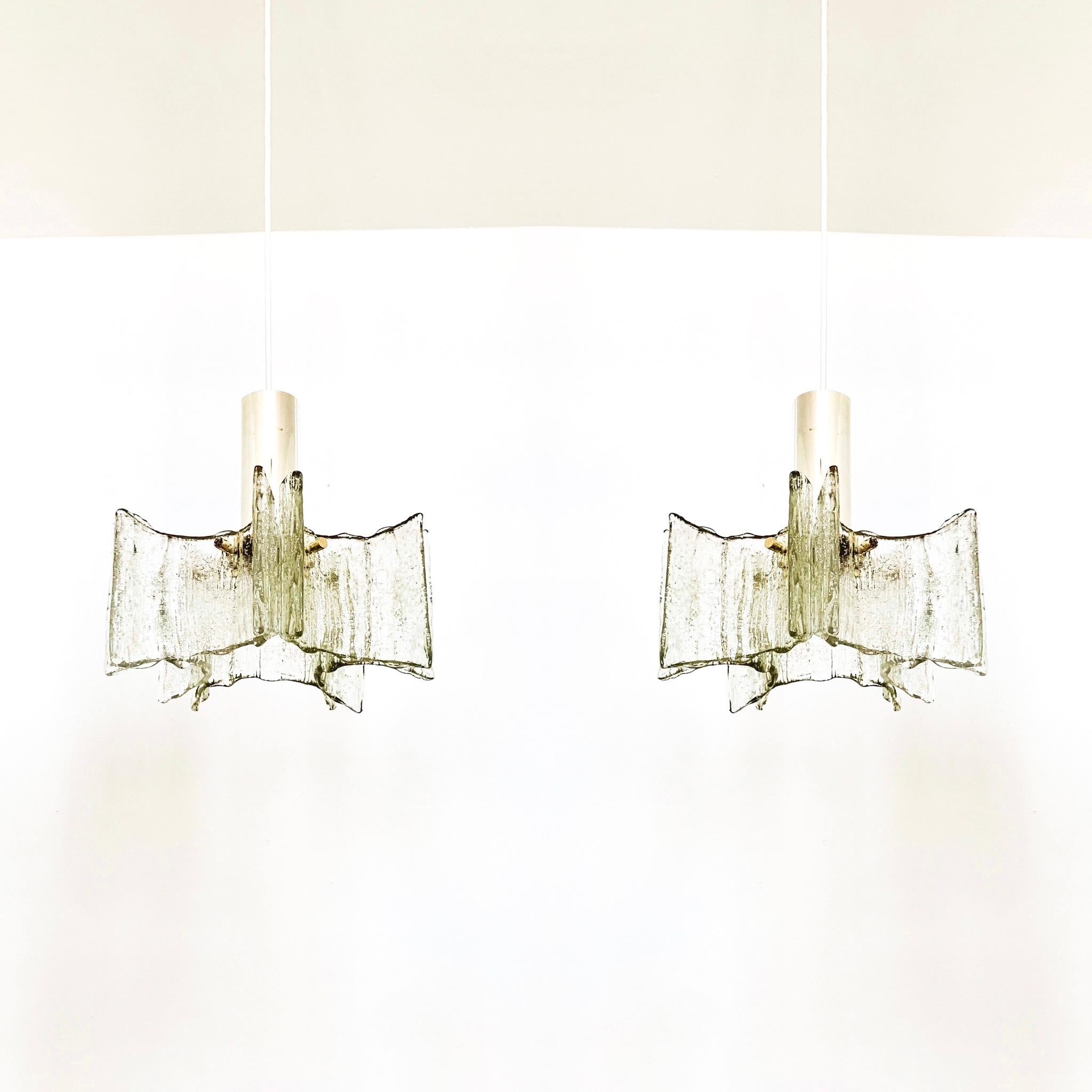 Very beautiful and high-quality ice glass pendant lamps from the 1960s.
The lamp with the 5 crystal pendants is very noble.
The structure of the glasses creates a very sparkling light.

Manufacturer: Kaiser Leuchten/ Kaiser