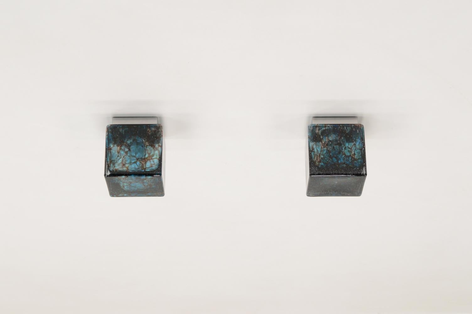 Set of 2 Cube flush mount ceiling lights by Glashütte Limburg, Germany 1970s. Thick blue glass cubes with bubbles and dark veins. Chrome mount that holds a E27 bulb. This is a rare set. Marked with Glashütte Limburg logo on the inside. In very good
