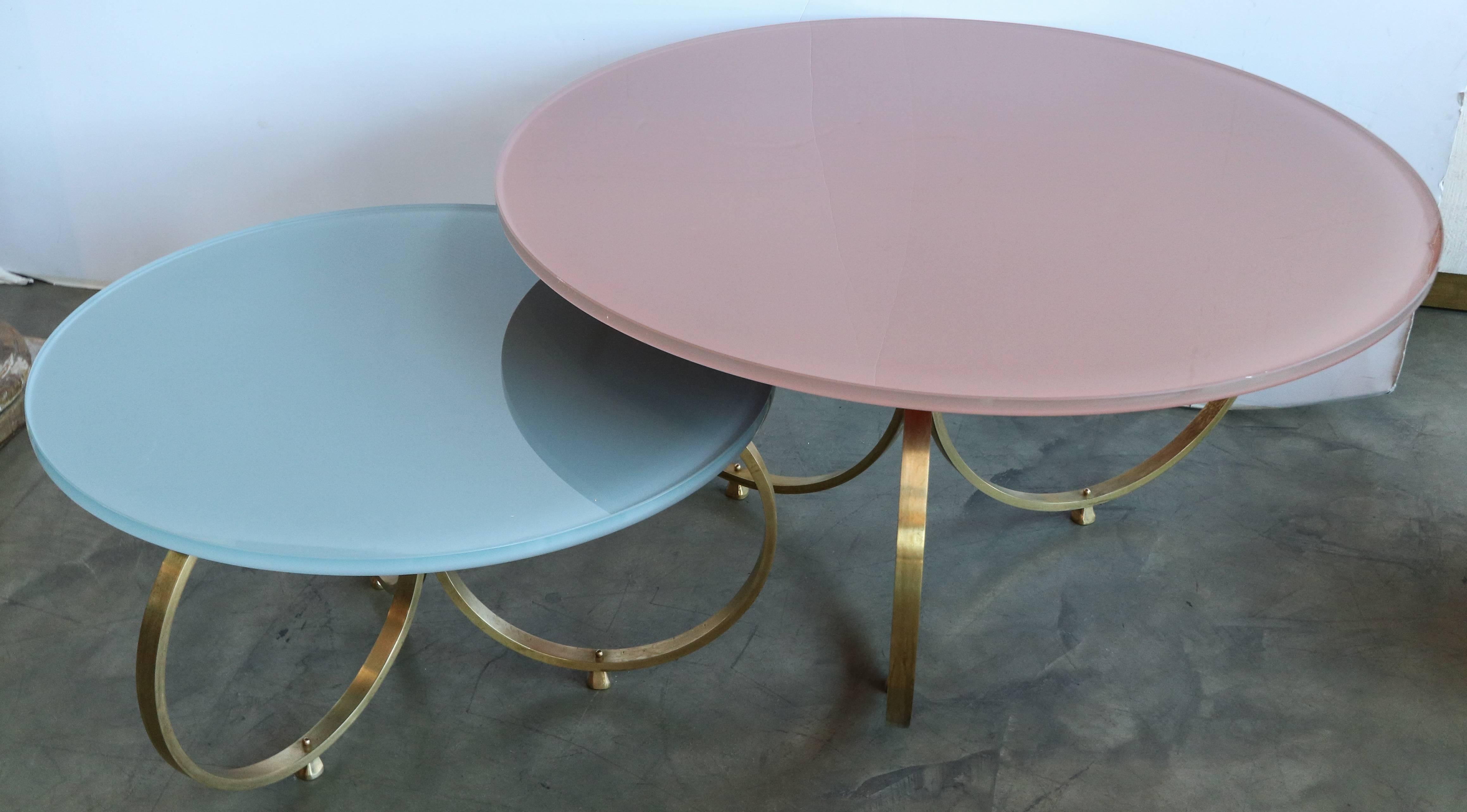 Set of two custom brass coffee tables with reverse painted glass tops in pink and grey blue.  Handmade in Los Angeles by Adesso Imports. Can be done in any color and multiple metals and finishes

Dimensions:
Small 30in diameter x 16.75in high
Large