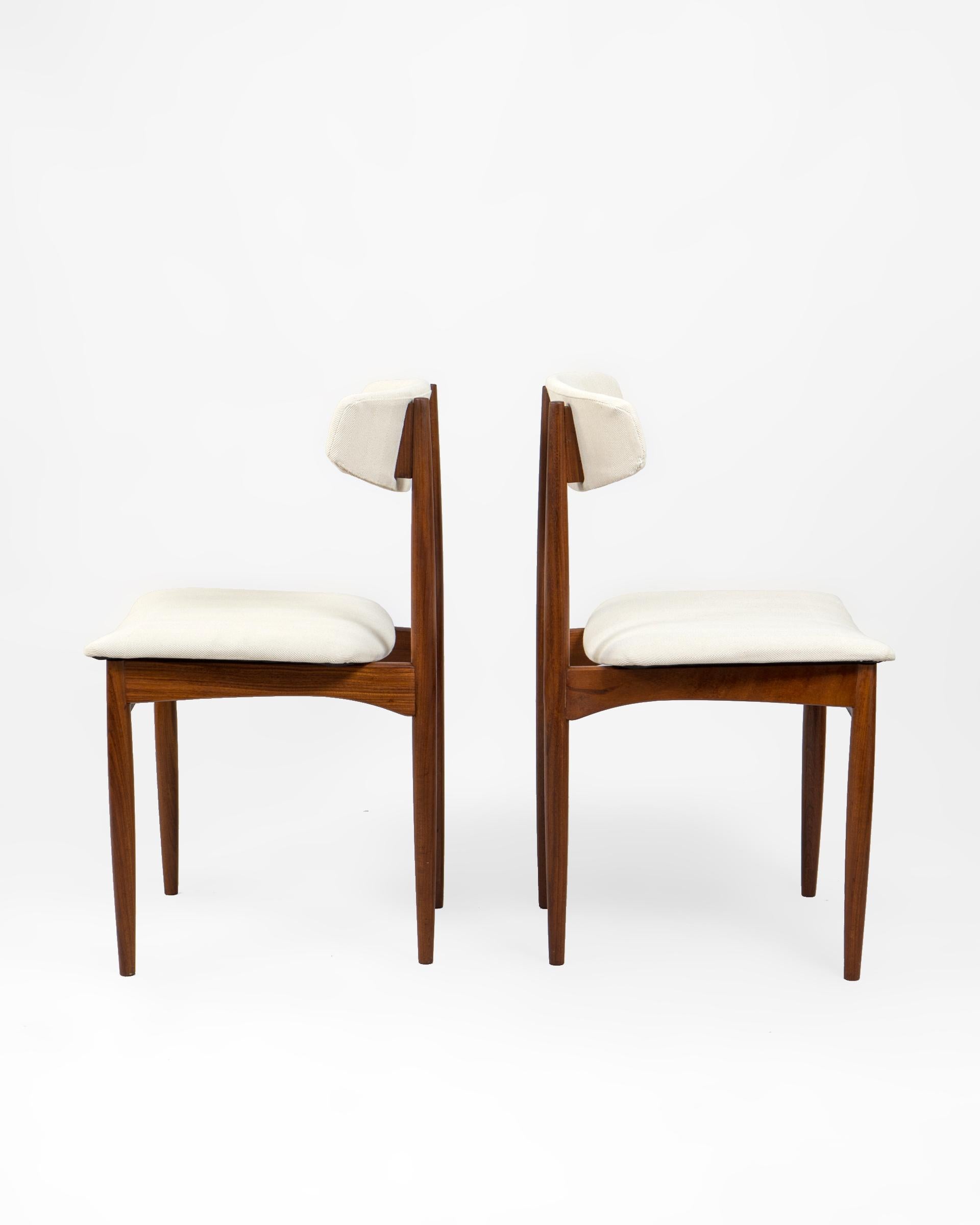 Conjunto de dos sillas danesas en madera afrormosia. Excelente y confortable diseño con respaldo en forma de boomerang y amplio asiento. Se han re tapizado en tejido de algodón de espiga beige fabricado en España en telar tradicional.

El torneado