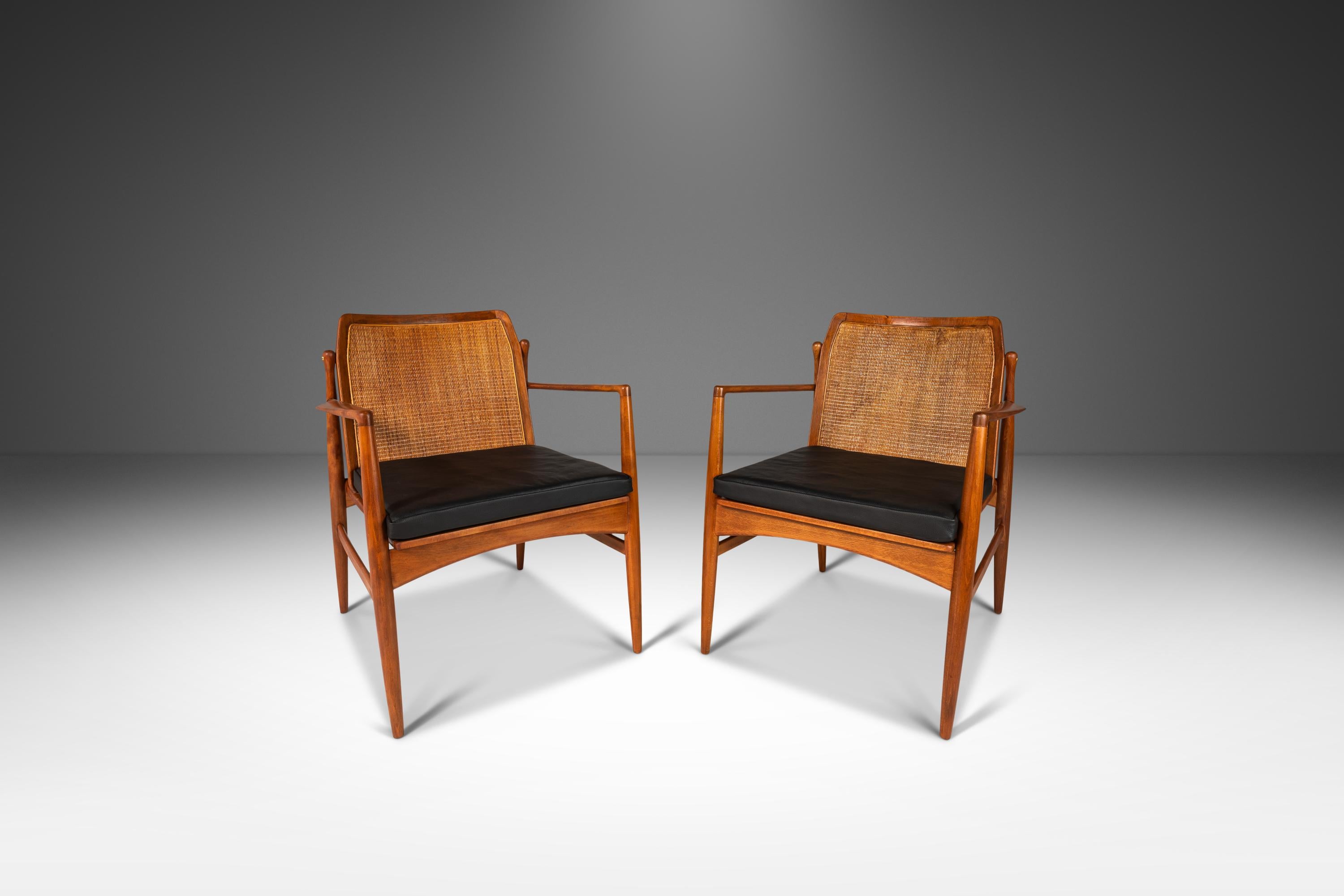 Introducing a true Danish Modern masterpiece: a set of two cane back lounge chairs designed by the incomparable Ib Kofod Larsen for Selig. This iconic set has been fully restored and newly upholstered, making it the perfect addition to any modern