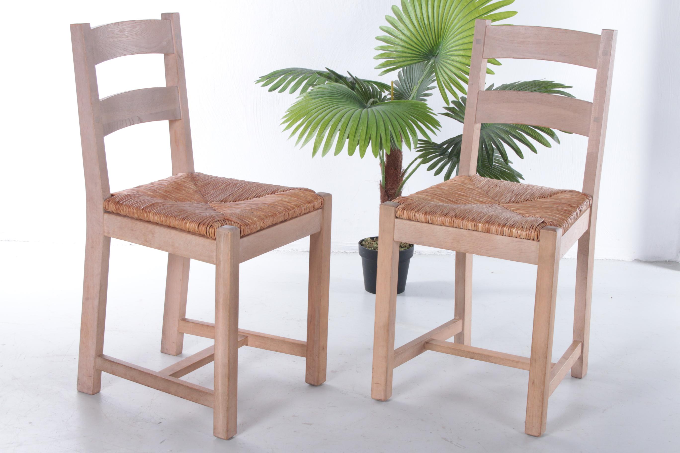 Beautiful set of 2 Danish oak kitchen chairs with wicker seat, produced in the 1970s. 

The chairs were bought in Denmark and also radiate a typical simplistic Scandinavian design, but the designer is unknown to us.

The chairs are very sturdy