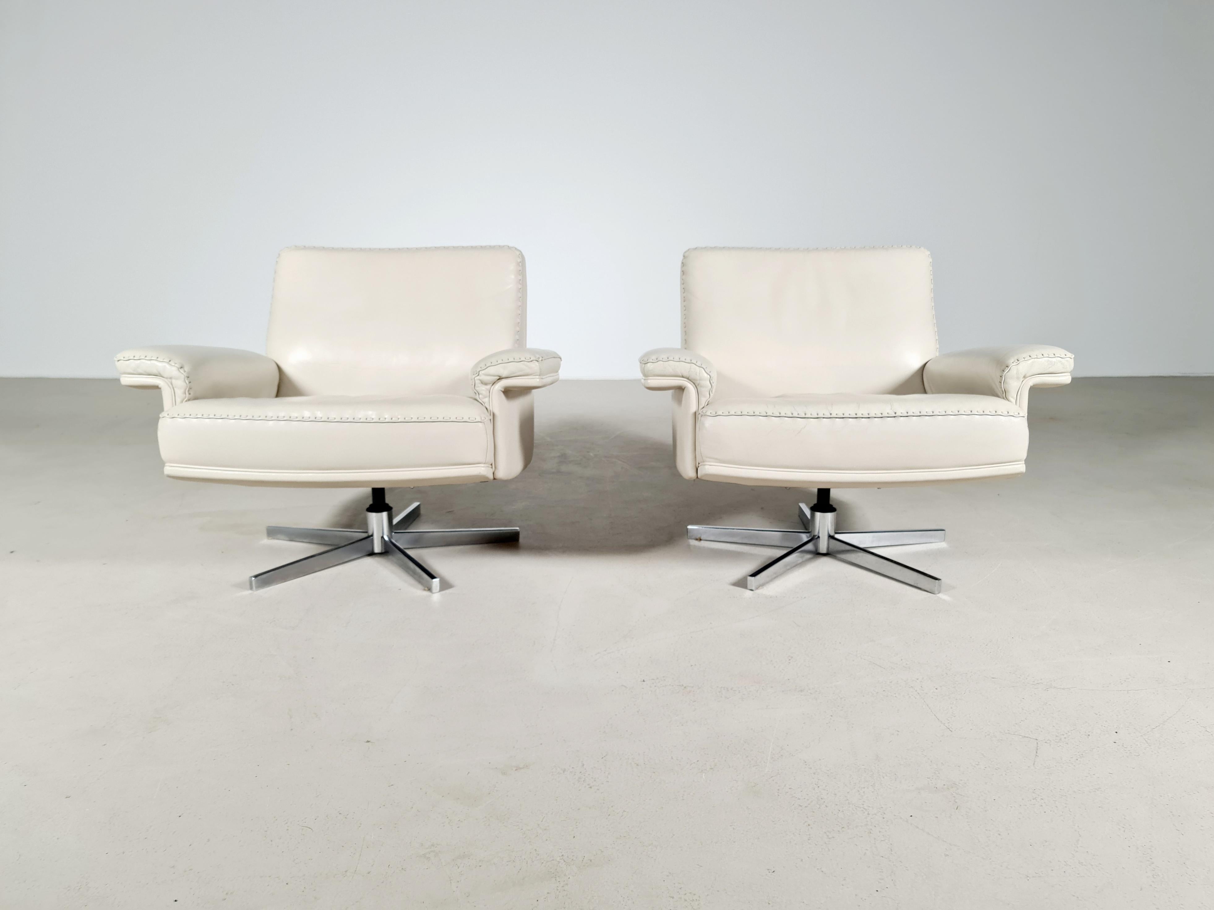 De Sede DS 35 swivel armchairs. Hand built in the 1970s by De Sede in Switzerland, this swivel armchair is extremely comfortable. Upholstered in stunning creme aniline leather with superb whipstitch edge detail standing on a polished chrome-plated