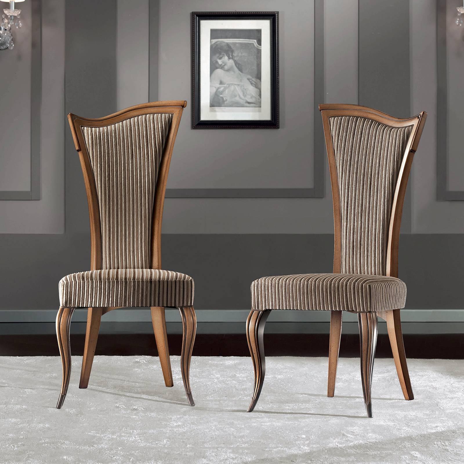 Baroque style meets Art Deco imagination in this sophisticated set of chairs that will transform any space with their timeless elegance. The contemporary silhouette features a tall, flared backrest with an asymmetrical top rail angled upwards. The