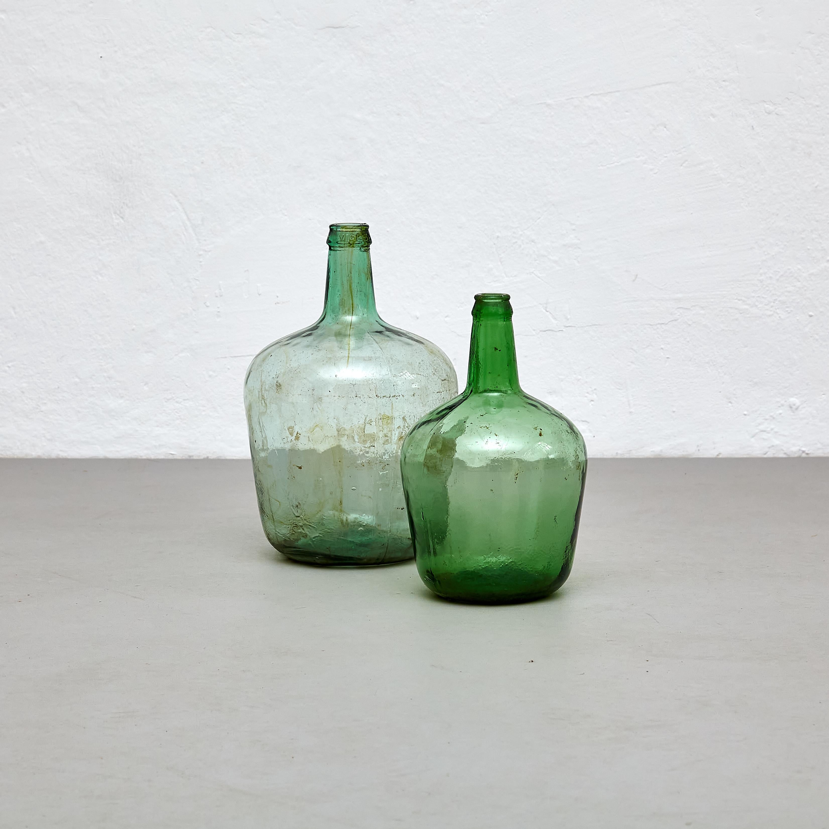Set of 2 Early 20th Centry Spanish Glass Bottle Vase.

Manufactured Spain, circa 1960.

Dimensions: 
L- Diam. 23.5 cm x H 36.5 cm.
M- Diam. 19 cm x H 31 cm.

In original condition, with minor wear consistent with age and use, preserving a