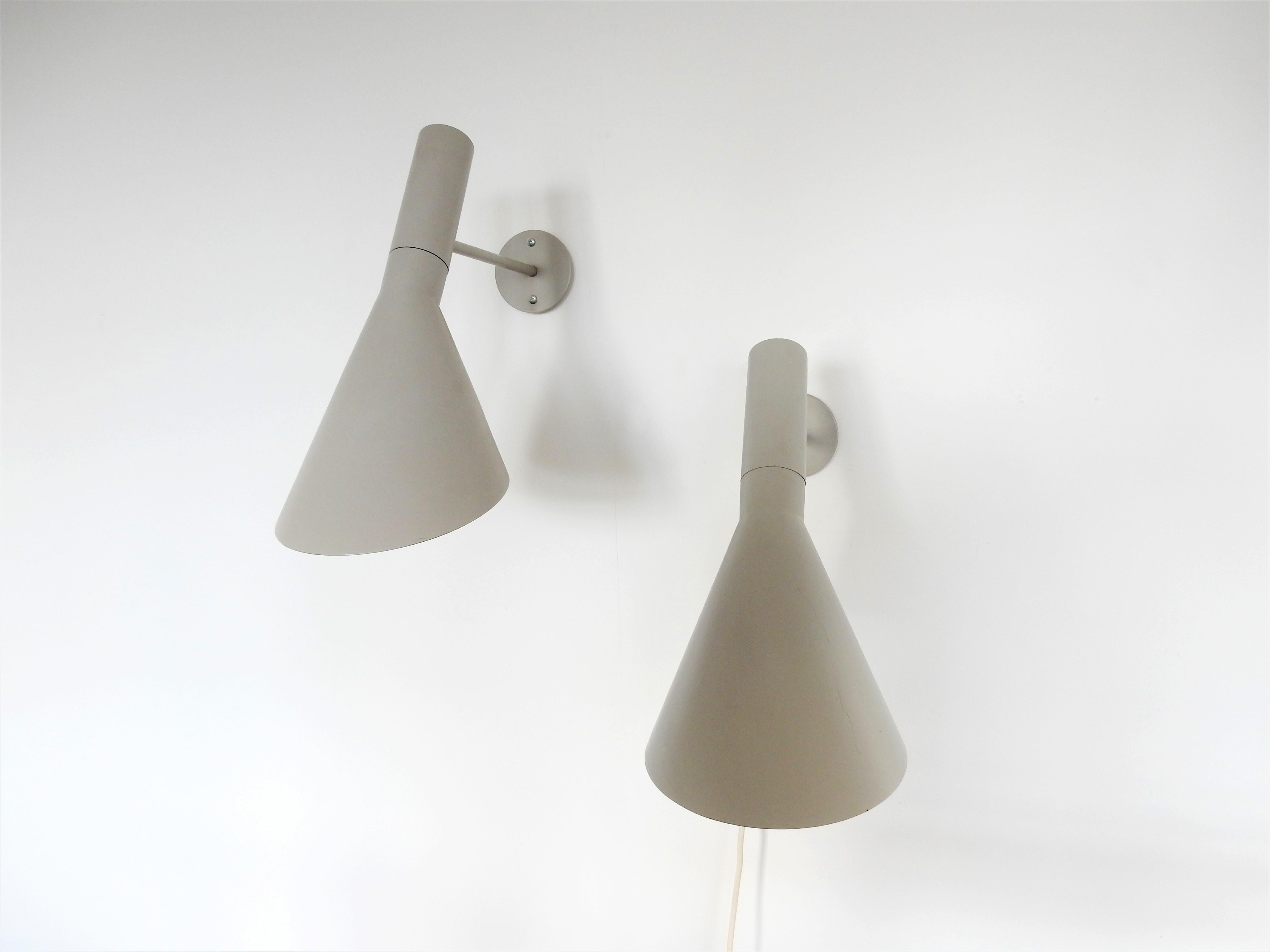 This rare and early set of 2 Visor AJ wall lamps are a design by Arne Jacobsen. He originally designed these for the Royal SAS House hotel in Copenhagen in 1958. These lamps were produced by Louis Poulsen in the 1960s. They are made of steel and