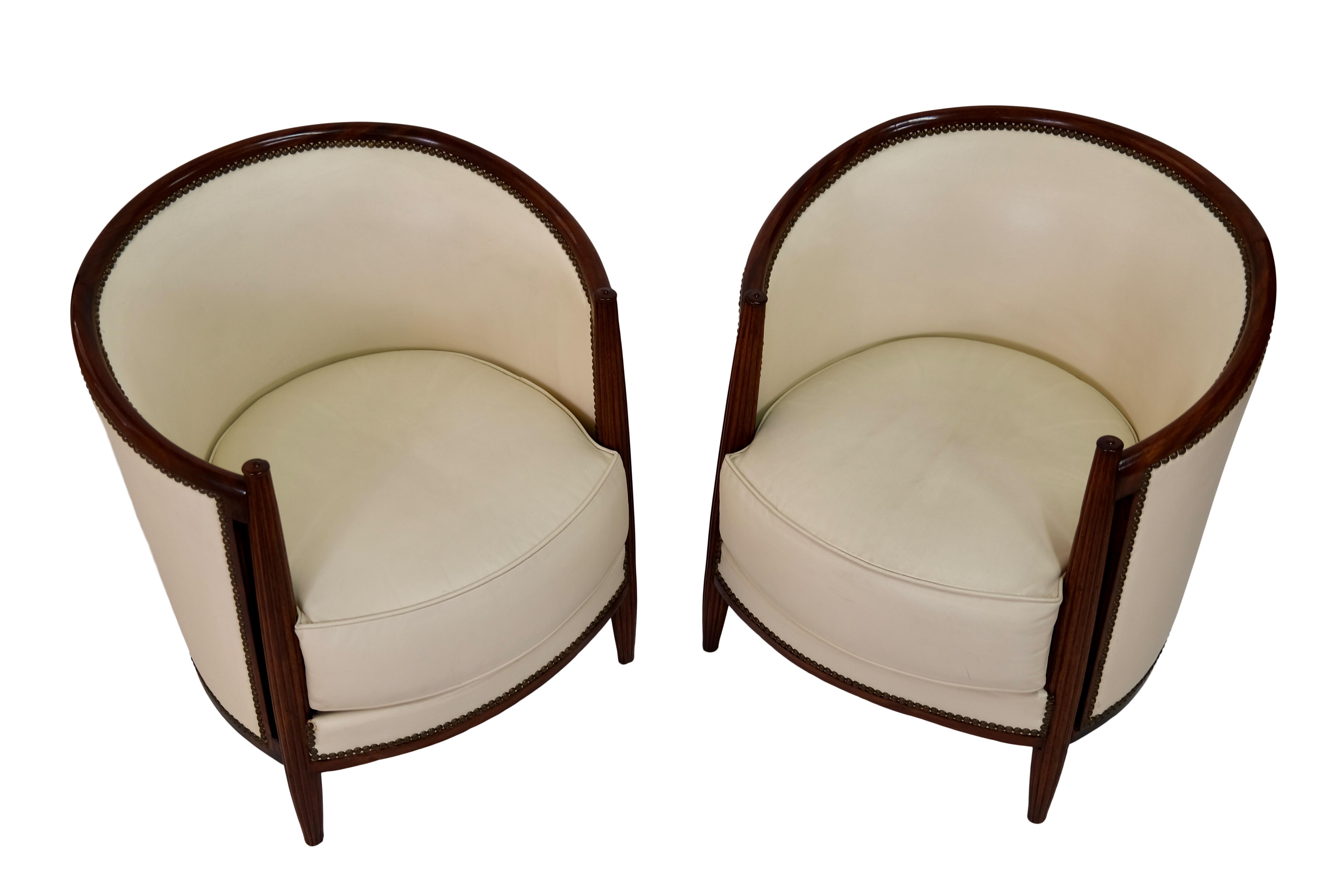 Pair of early Art Deco club chairs
Channeled legs
Solid Mahogany
Beige colored leather, reupholstery in the past 

Early Art Deco, France circa 1925

Dimensions: 
Width: 66cm
Height: 72 cm
Depth: 66 cm
Seat height: 44 cm.