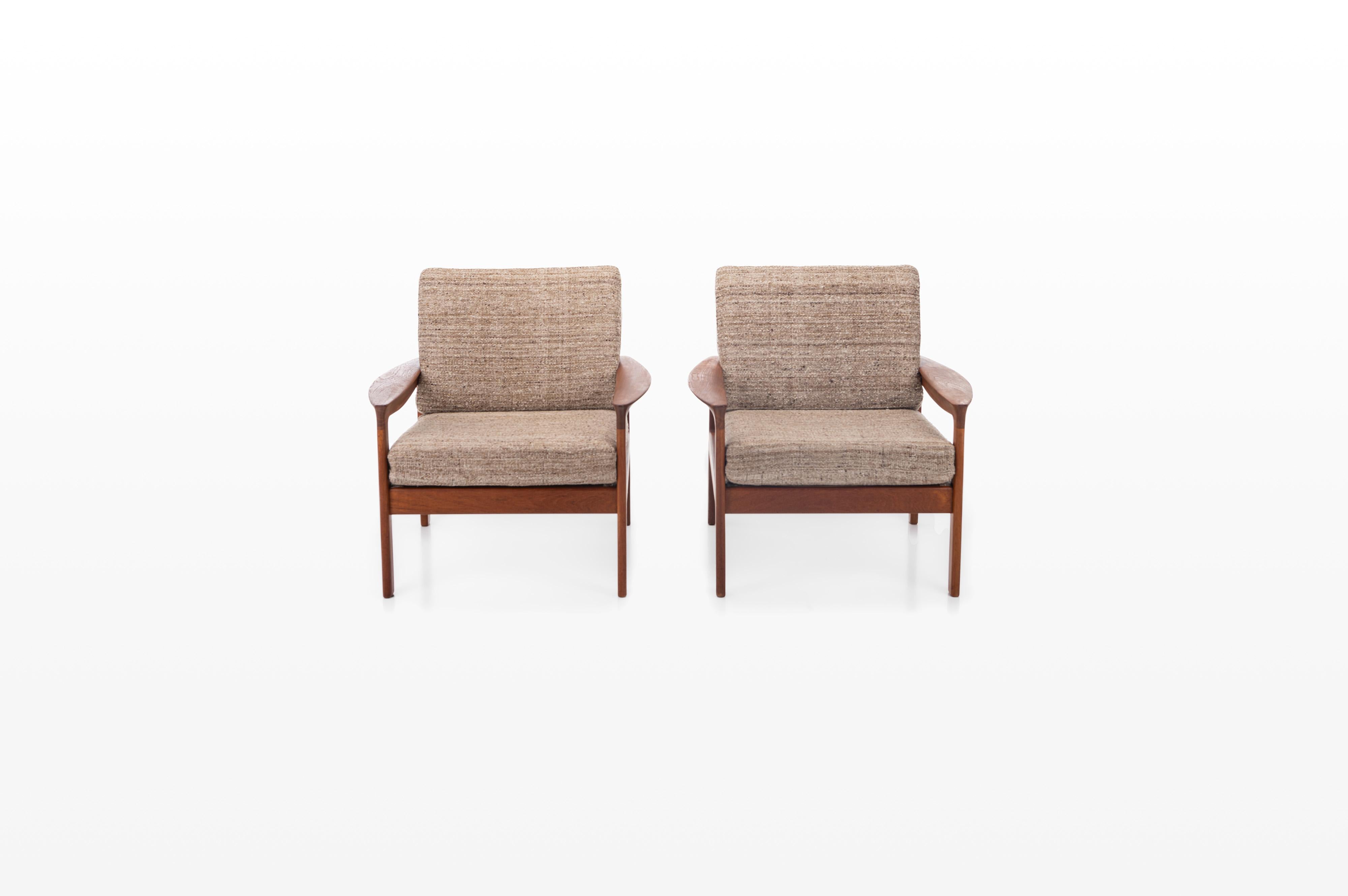 Pair of easy chairs designed by Arne Wahl Iversen and manufactured by Komfort, Denmark 1960s. The armchairs have a teak frame and the cushions still have a beige wool upholstery.