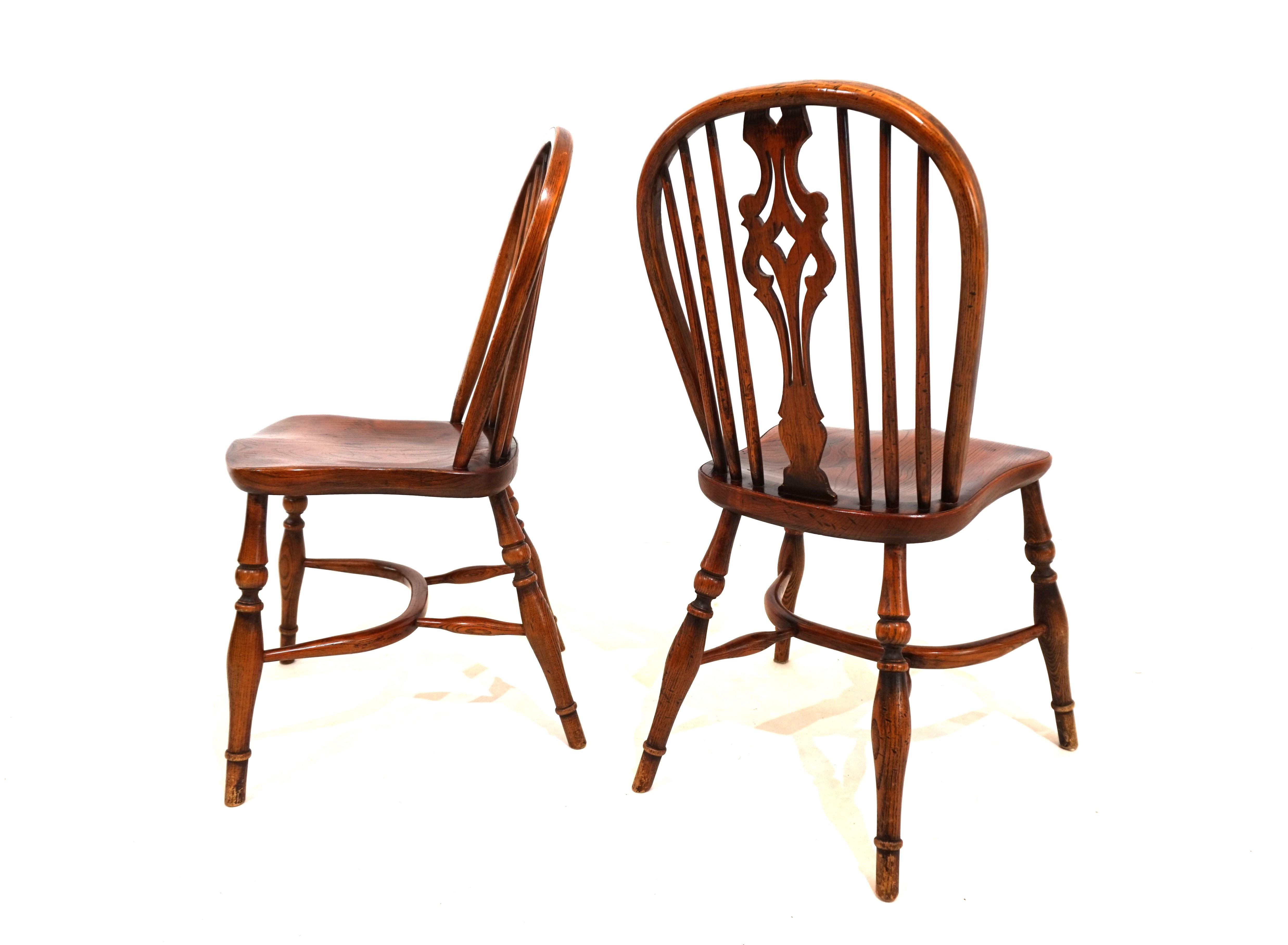 The pair of 2 classic Windsor chairs without armrests are in very good condition with a beautiful patina of age. The chairs have an attractive design element on the backrest and are solidly crafted. Over the years, they have developed signs of wear