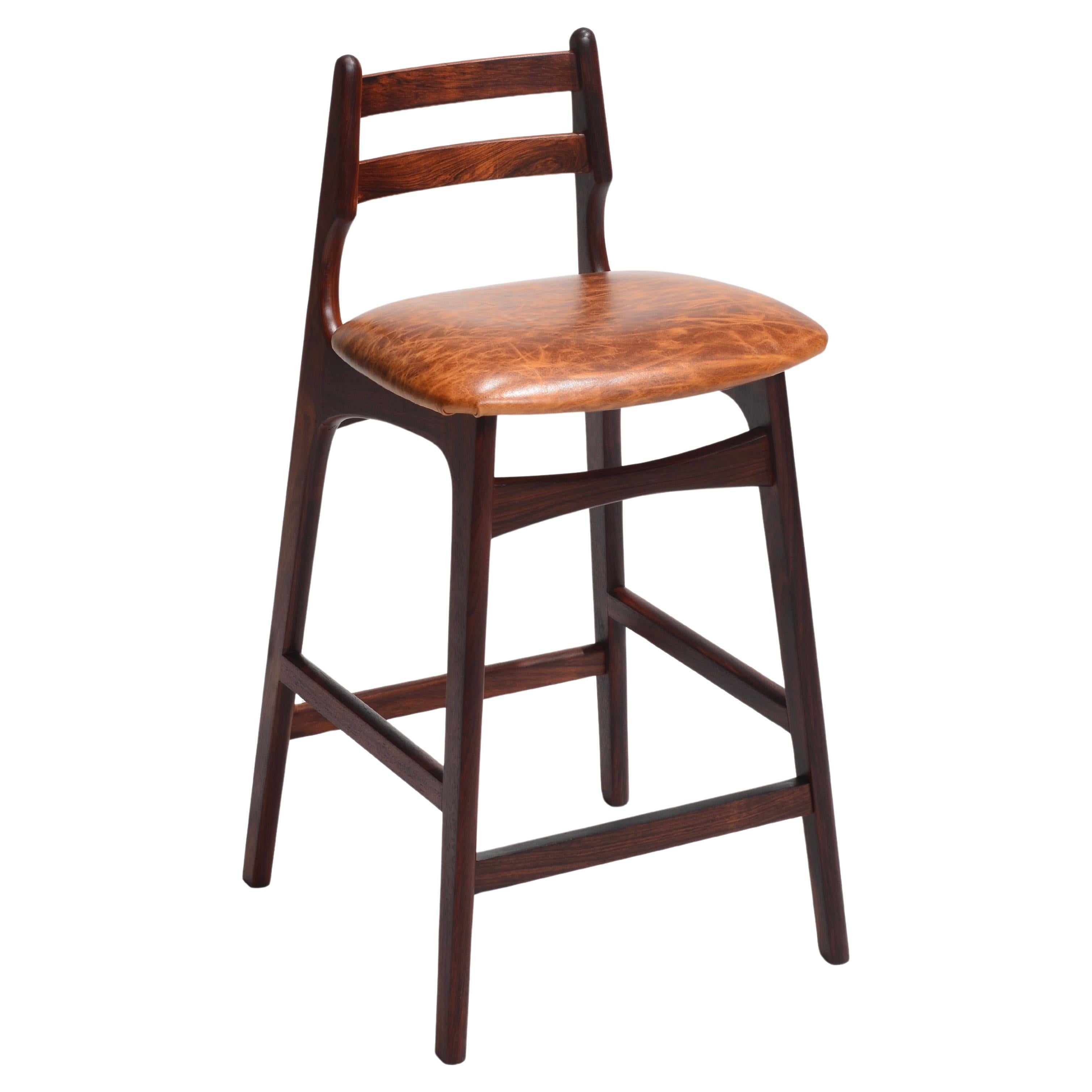 The Mid-Century Danish Modern Rosewood counter Stool by Erik Buck, embodies the quintessential elegance and timeless appeal of mid-century Scandinavian design. Crafted with meticulous attention to detail, this counter stool pays homage to the iconic