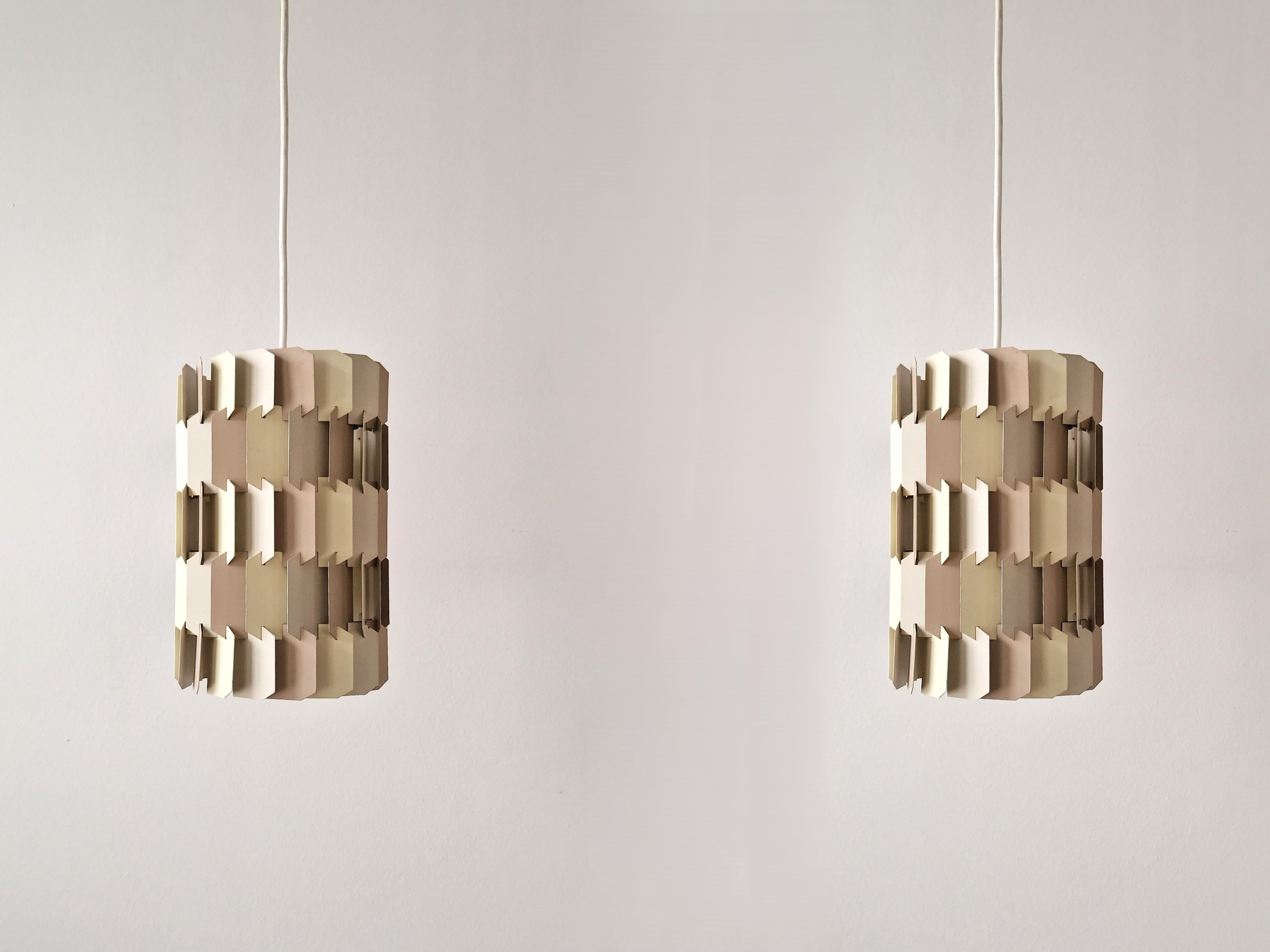 The 'Facet-pop' pendant lamp was designed by Louis Weisdorf for Lyfa in Denmark in the 1960's. It is made out of many small metal parts that are put together. The dynamic layered shape is a true signature of Weisdorf. This version has pastel/beige