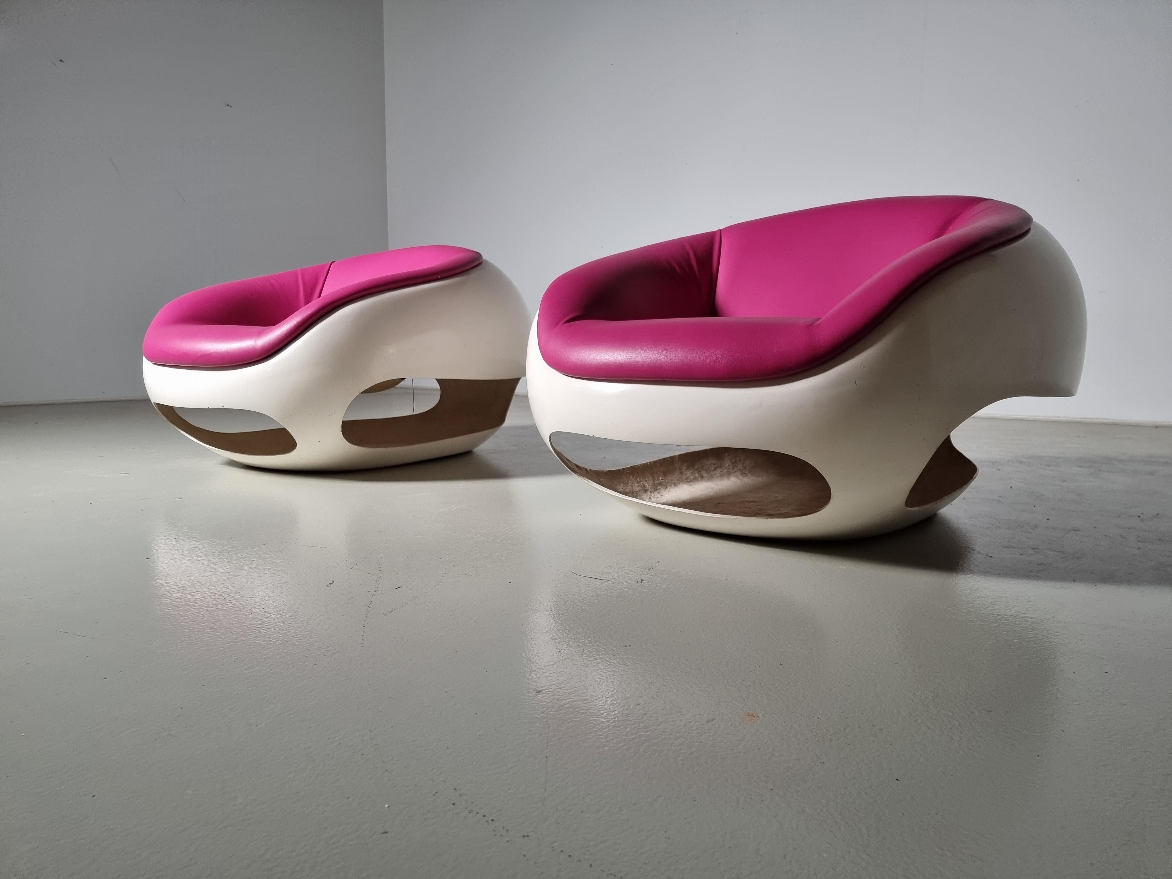 Postmodern pair of lounge chairs by Italian designer Mario Sabot. The design is inspired by the GT series of Ferrari in the 1960s. The cutouts are shaped after the grill and wheel arch of the iconic sports car. Cream white fiberglass base and the
