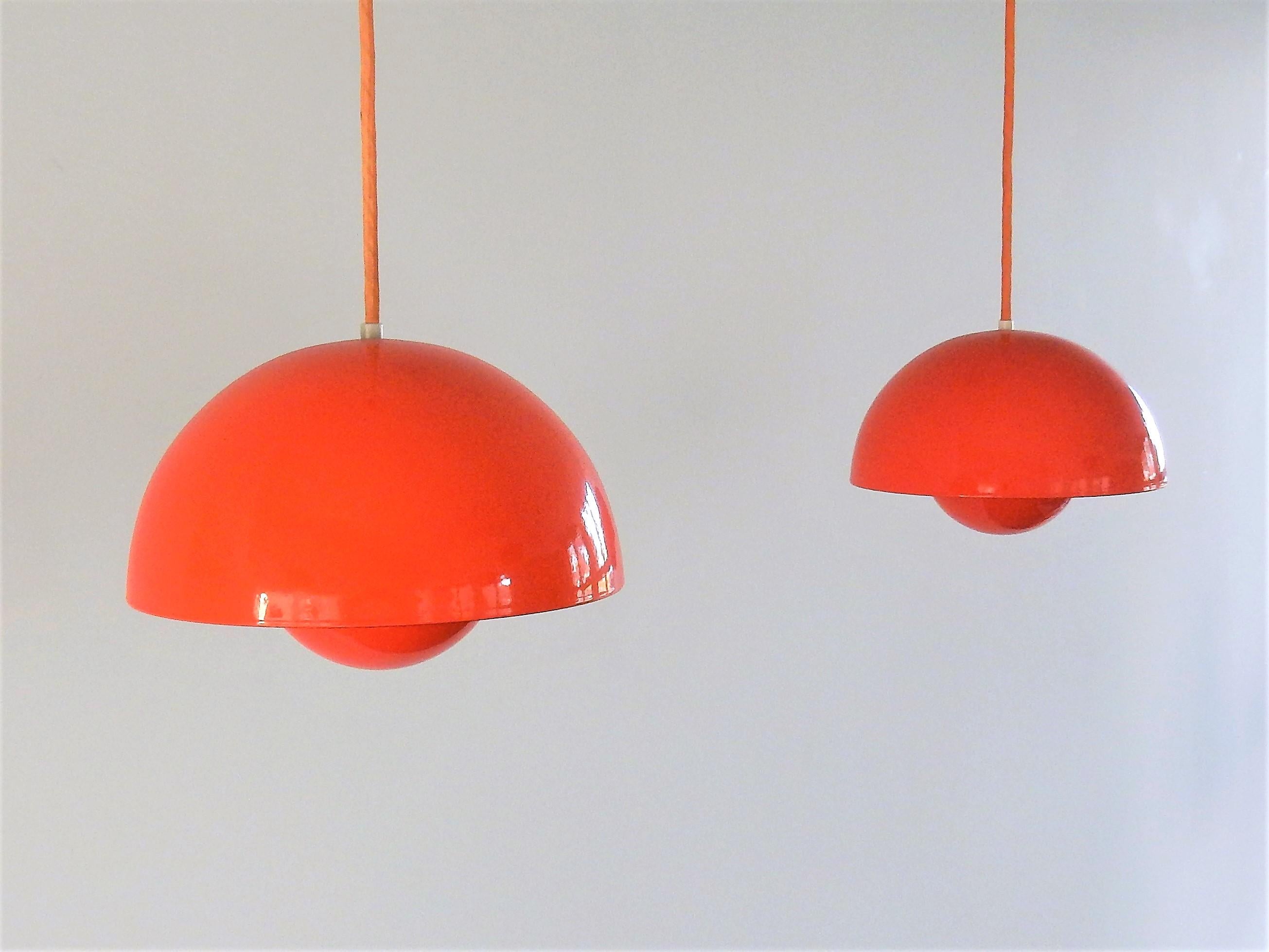 This set of 2 red enameled flowerpot lamps, no. 16562, was designed by Verner Panton for Louis Poulsen. The lamps have a red enameled finish outside and bright white enameled inside. The reflector shade has red enamel on both sides that gives a nice