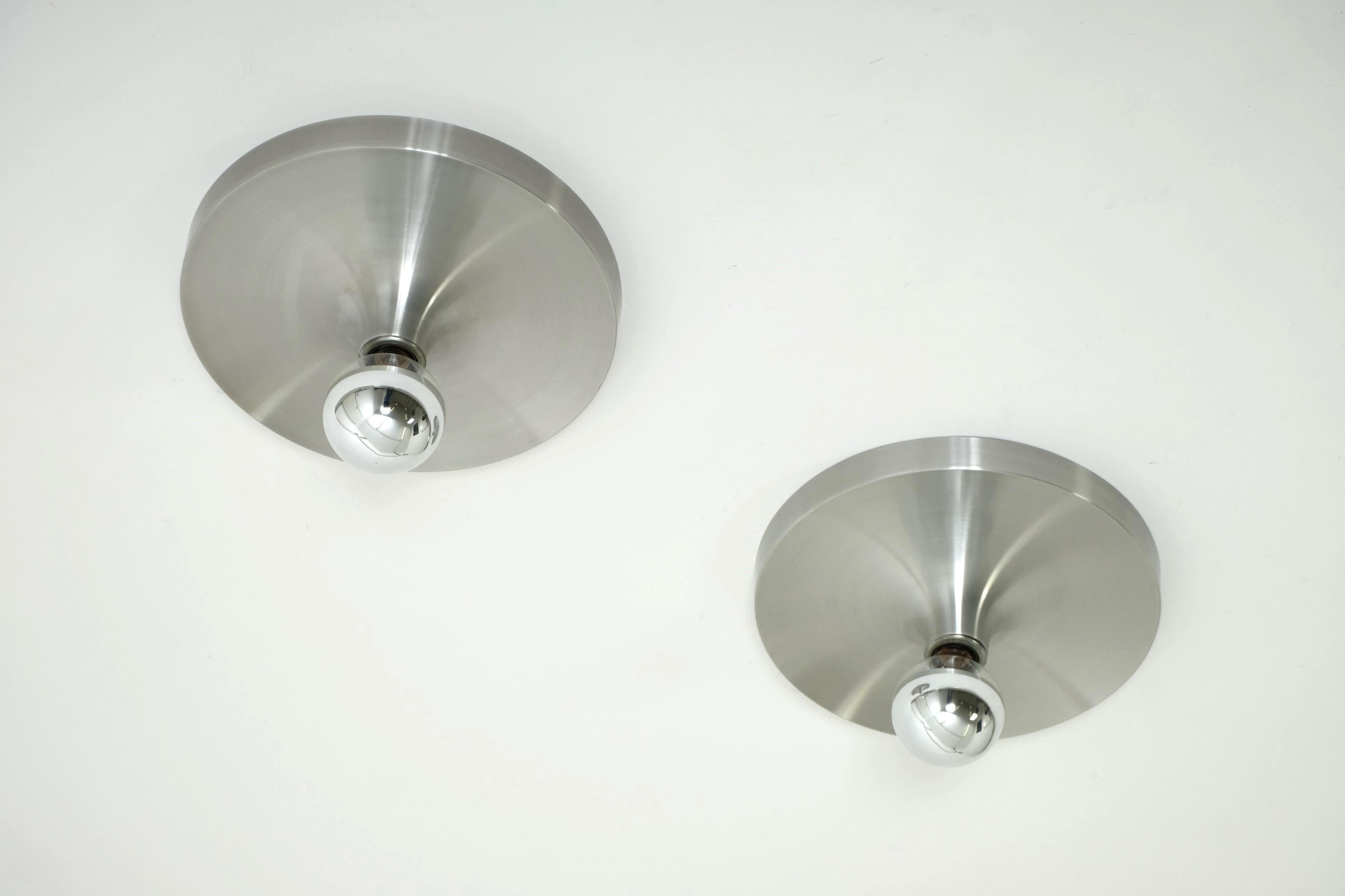 Set of two aluminum flush mount or wall lights, made in Germany by Teka Lighting in the 1970s.

This type of lamps was chosen by Charlotte Perriand for the Les Arcs ski resort (France) at the end of the 1960s.

100% original condition and fully