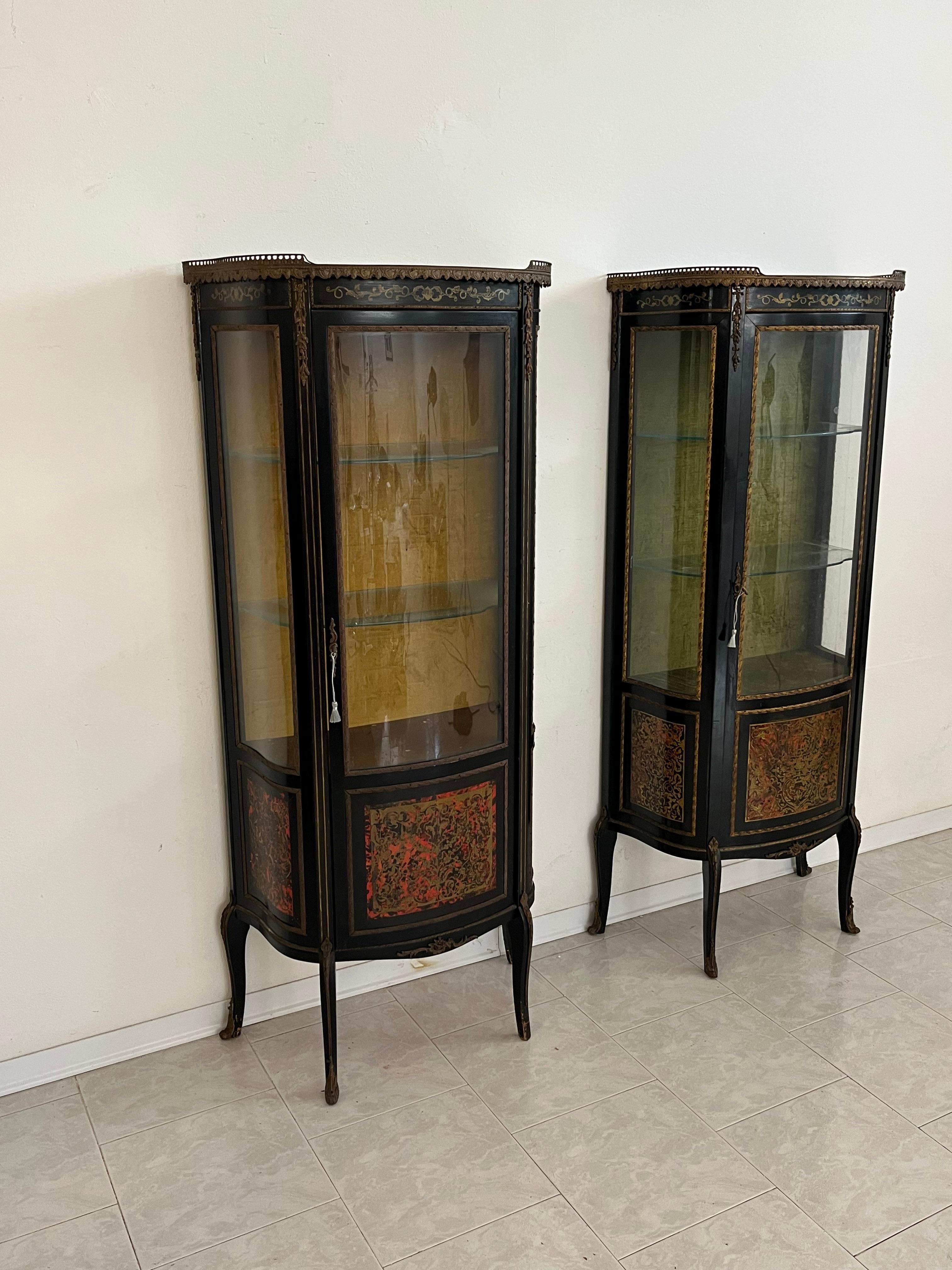 Set di 2 vetrine francesi Boulle, anni '30
Legno ebanizzato con intarsi in ottone su sfondo rosso. Interno foderato in Fabrice, due ripiani in vetro e uno scomparto. Apertura frontale con porta e vetro curvo. Decorazioni e dettagli in bronzo