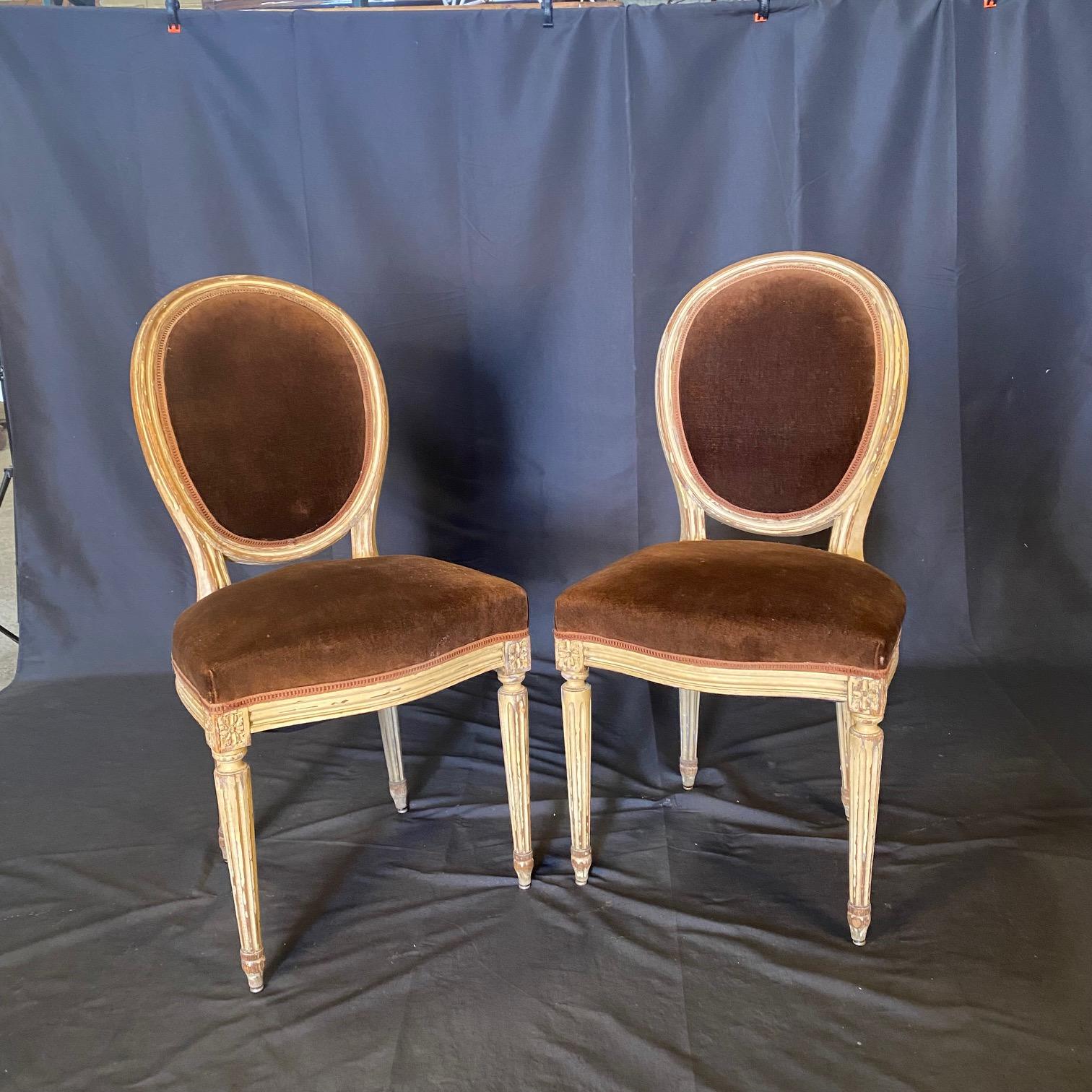 Set of 2 French Louis XVI early 19th century dining or side chairs having their original chocolate brown mohair upholstery, and lovely off white/cream painted frames with aged (original) distressed painted finish, standing on tapered reeded legs.